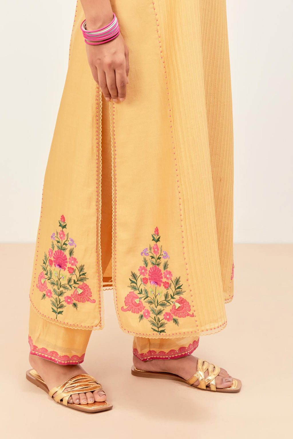 Yellow silk chanderi kurta set with pin tucks in the front & back and floral applique boota at sides, highlighted with aari threadwork & sequins.