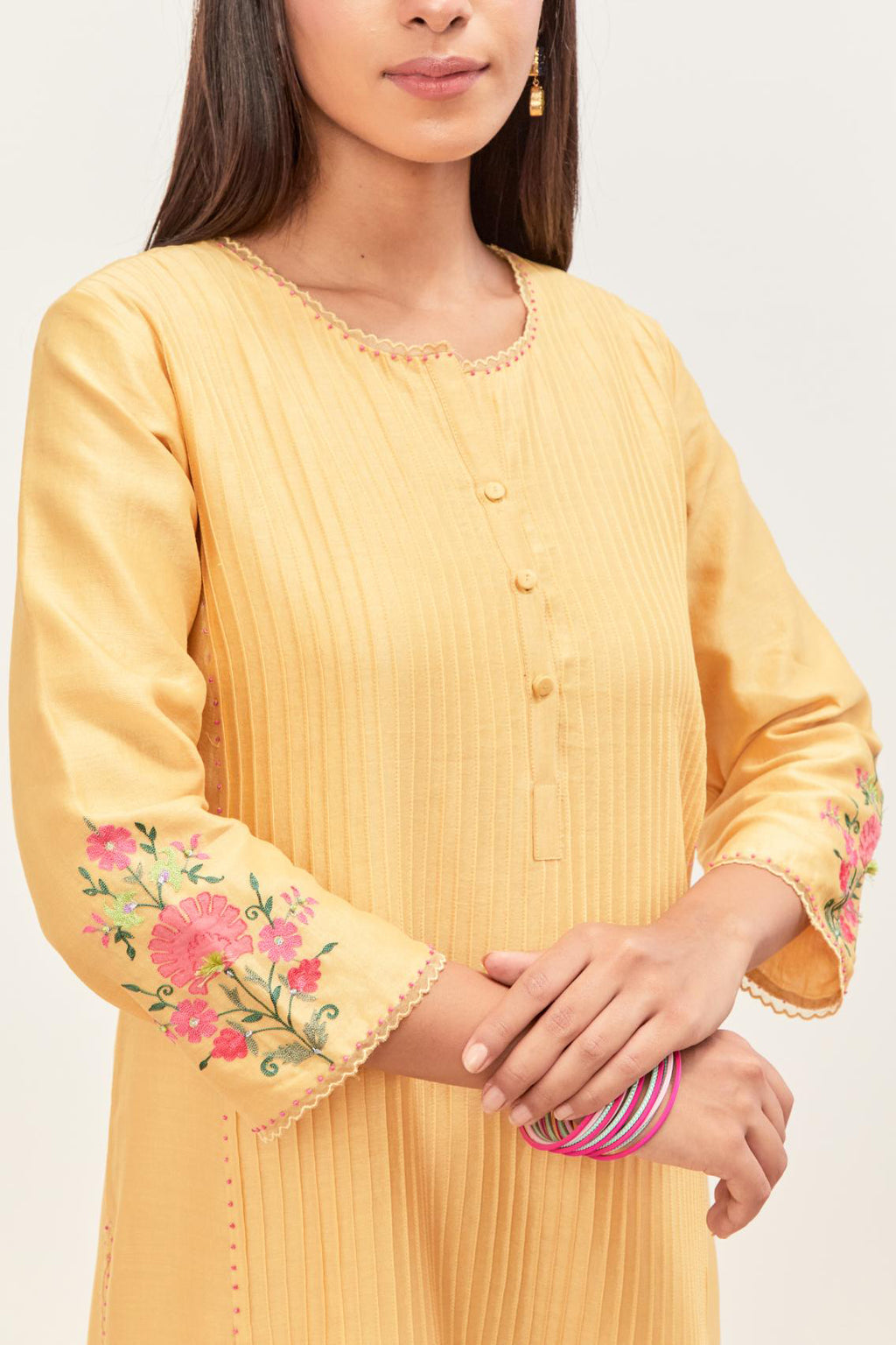 Yellow silk chanderi kurta set with pin tucks in the front & back and floral applique boota at sides, highlighted with aari threadwork & sequins.