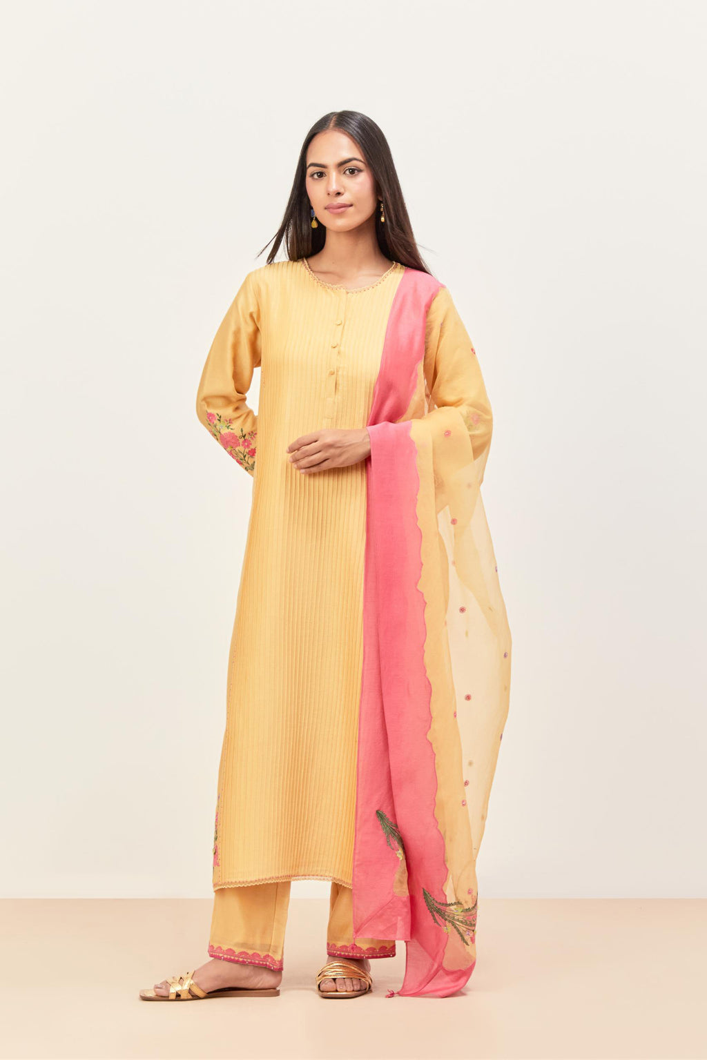 Yellow silk chanderi kurta set with pin tucks in the front & back and floral applique boota at sides, highlighted with aari threadwork & sequins.