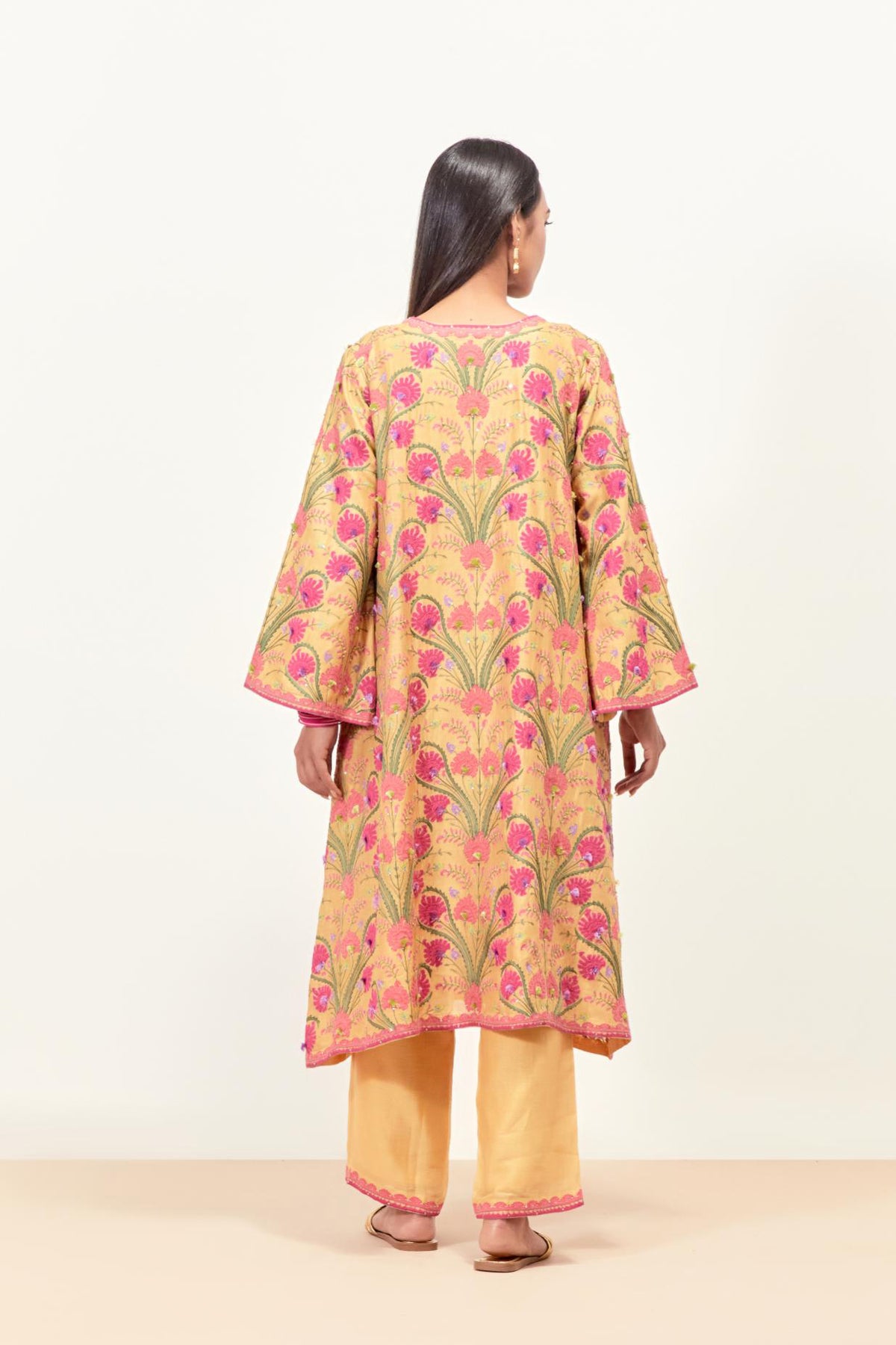 Yellow short A-line silk chanderi kurta set, fully embroidered with appliqué flowers, highlighted with aari thread work and silk tassels.