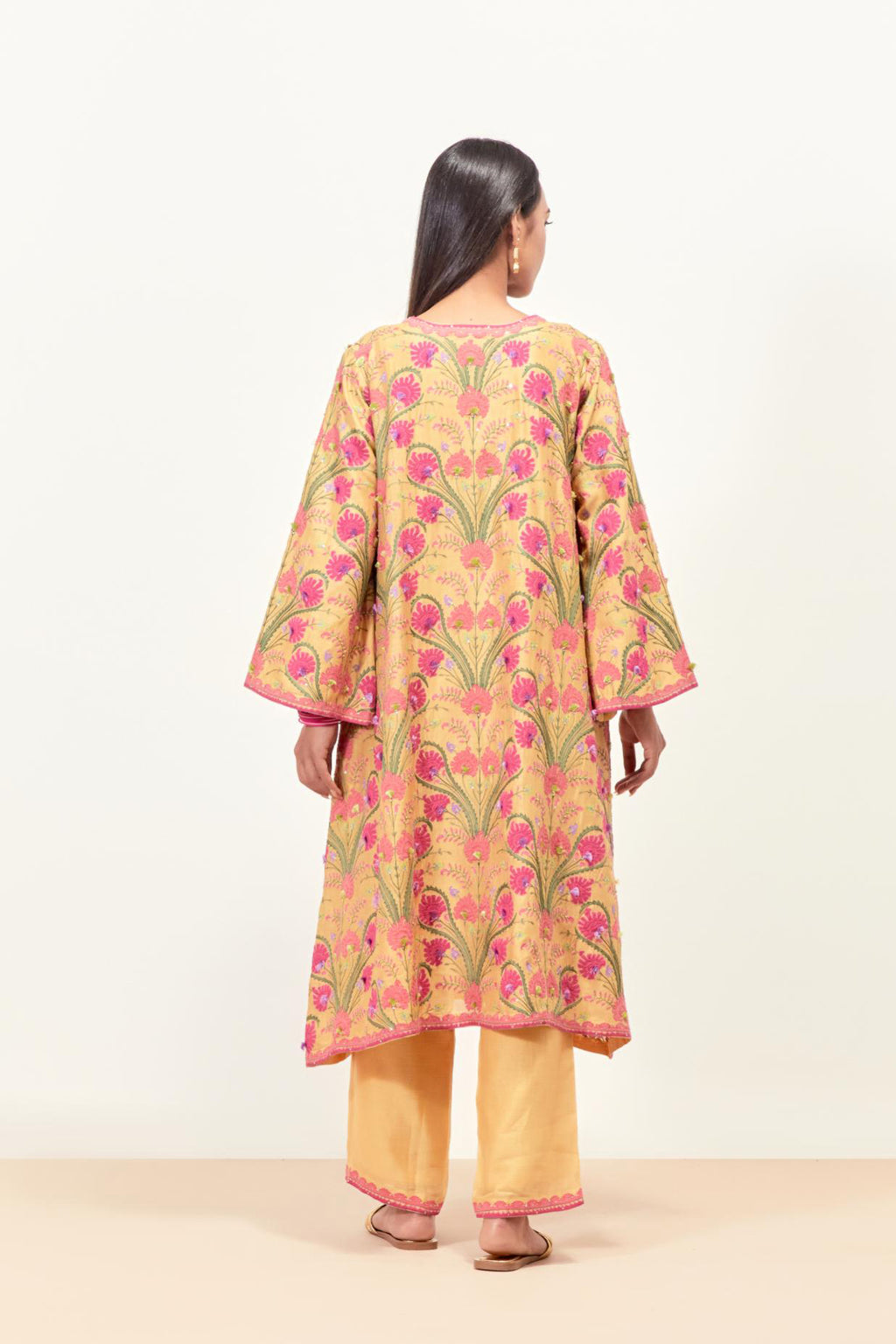 Yellow short A-line silk chanderi kurta set, fully embroidered with appliqué flowers, highlighted with aari thread work and silk tassels.
