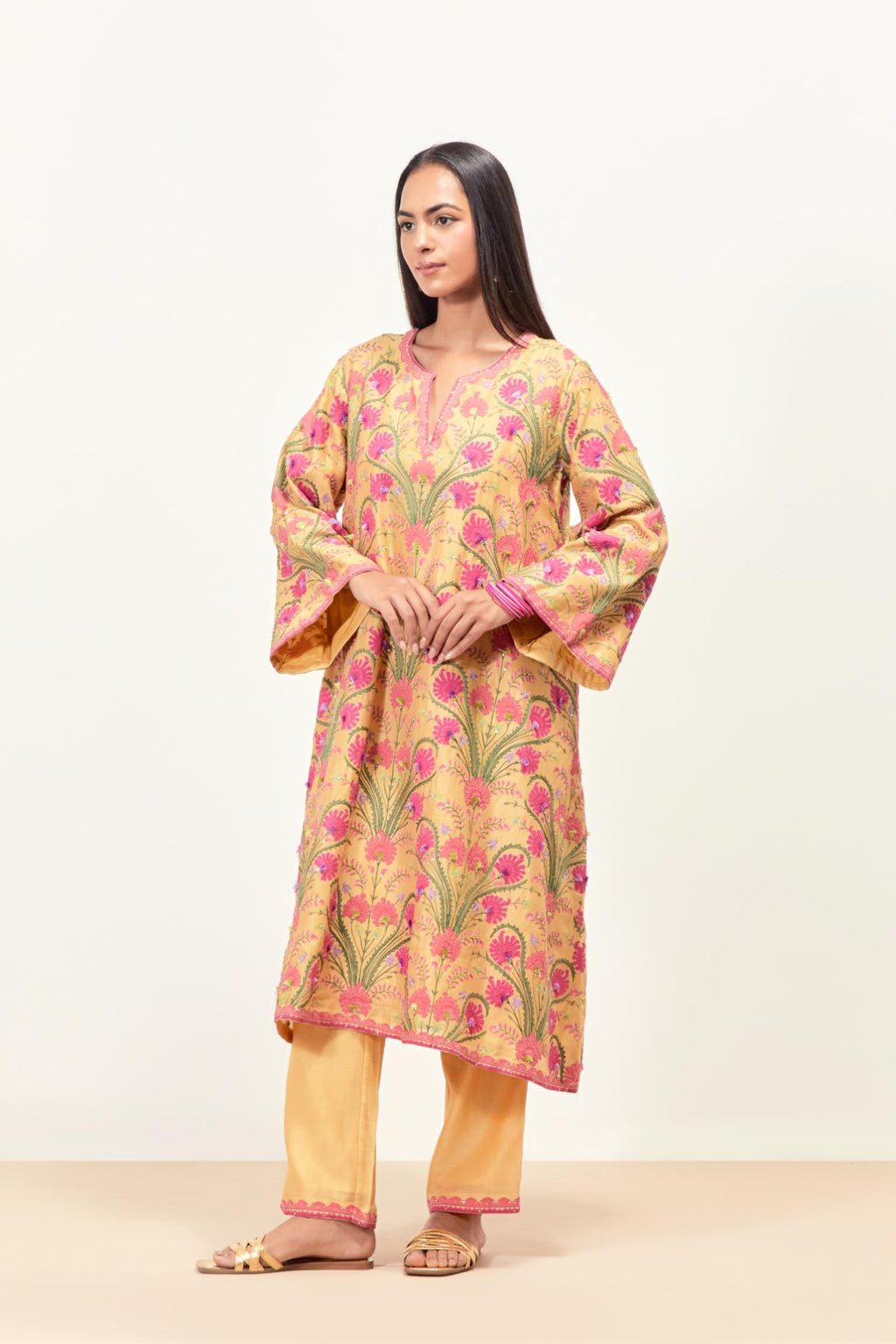 Yellow short A-line silk chanderi kurta set, fully embroidered with appliqué flowers, highlighted with aari thread work and silk tassels.