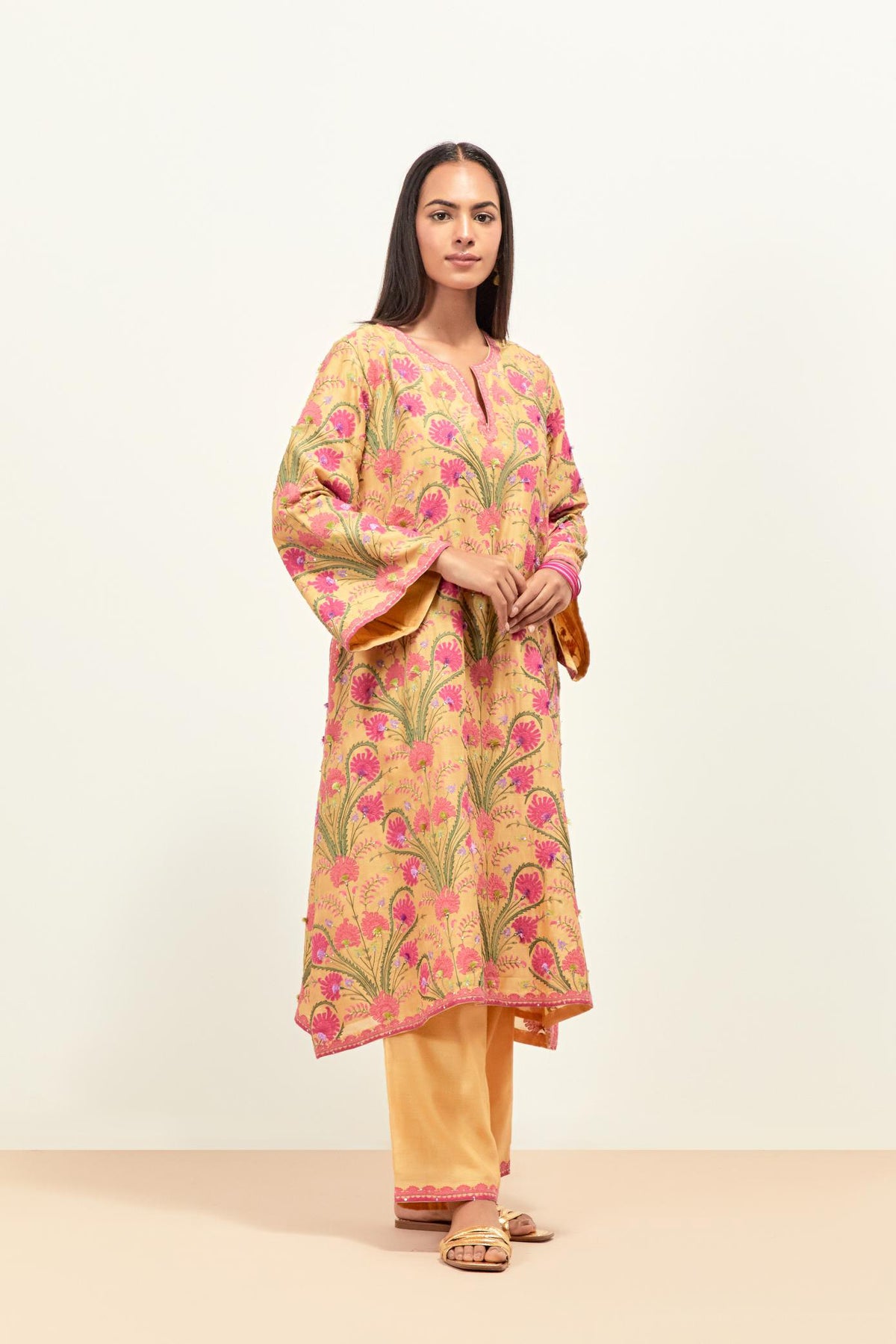 Yellow short A-line silk chanderi kurta set, fully embroidered with appliqué flowers, highlighted with aari thread work and silk tassels.