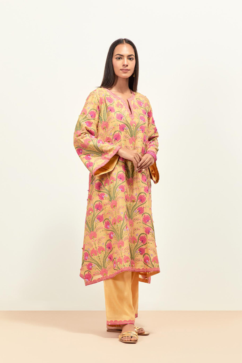 Yellow short A-line silk chanderi kurta set, fully embroidered with appliqué flowers, highlighted with aari thread work and silk tassels.