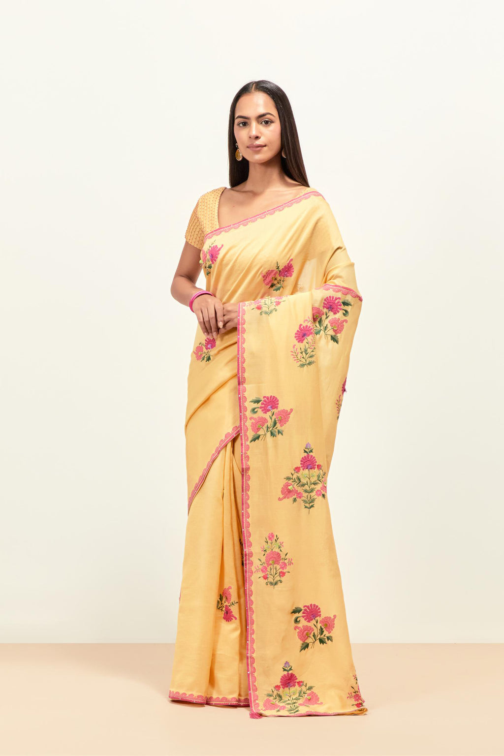 Yellow silk chanderi saree with all-over applique floral boota, highlighted with aari thread work and sequins, paired with yellow silk chanderi blouse with pin tucks in front, highlighted with bead work.
