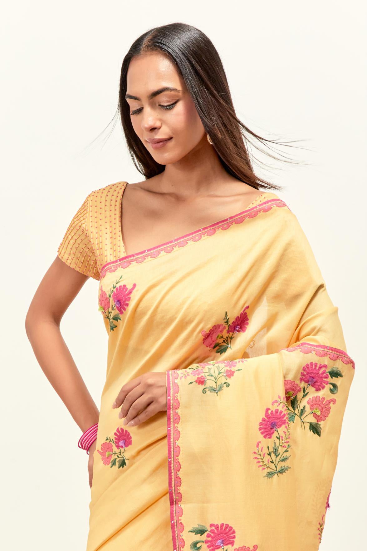 Yellow silk chanderi saree with all-over applique floral boota, highlighted with aari thread work and sequins, paired with yellow silk chanderi blouse with pin tucks in front, highlighted with bead work.