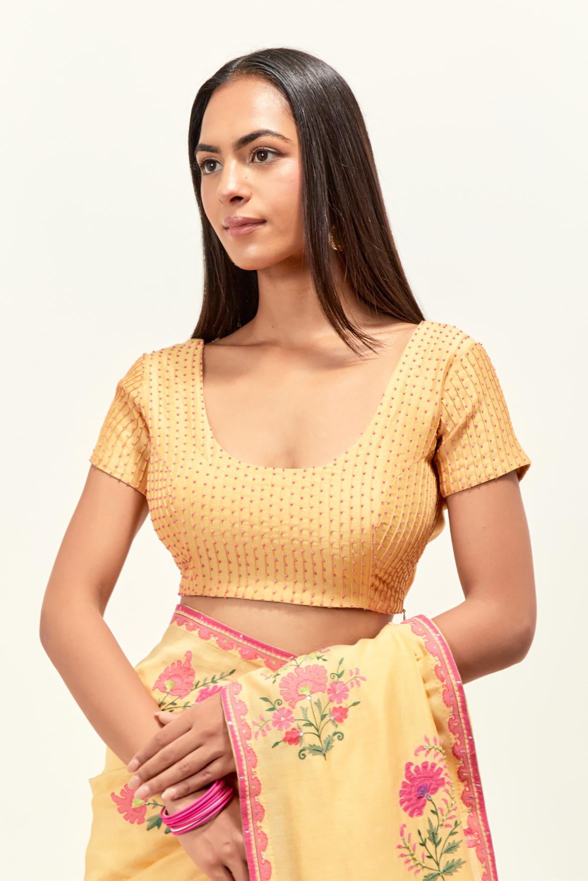 Yellow silk chanderi saree with all-over applique floral boota, highlighted with aari thread work and sequins, paired with yellow silk chanderi blouse with pin tucks in front, highlighted with bead work.