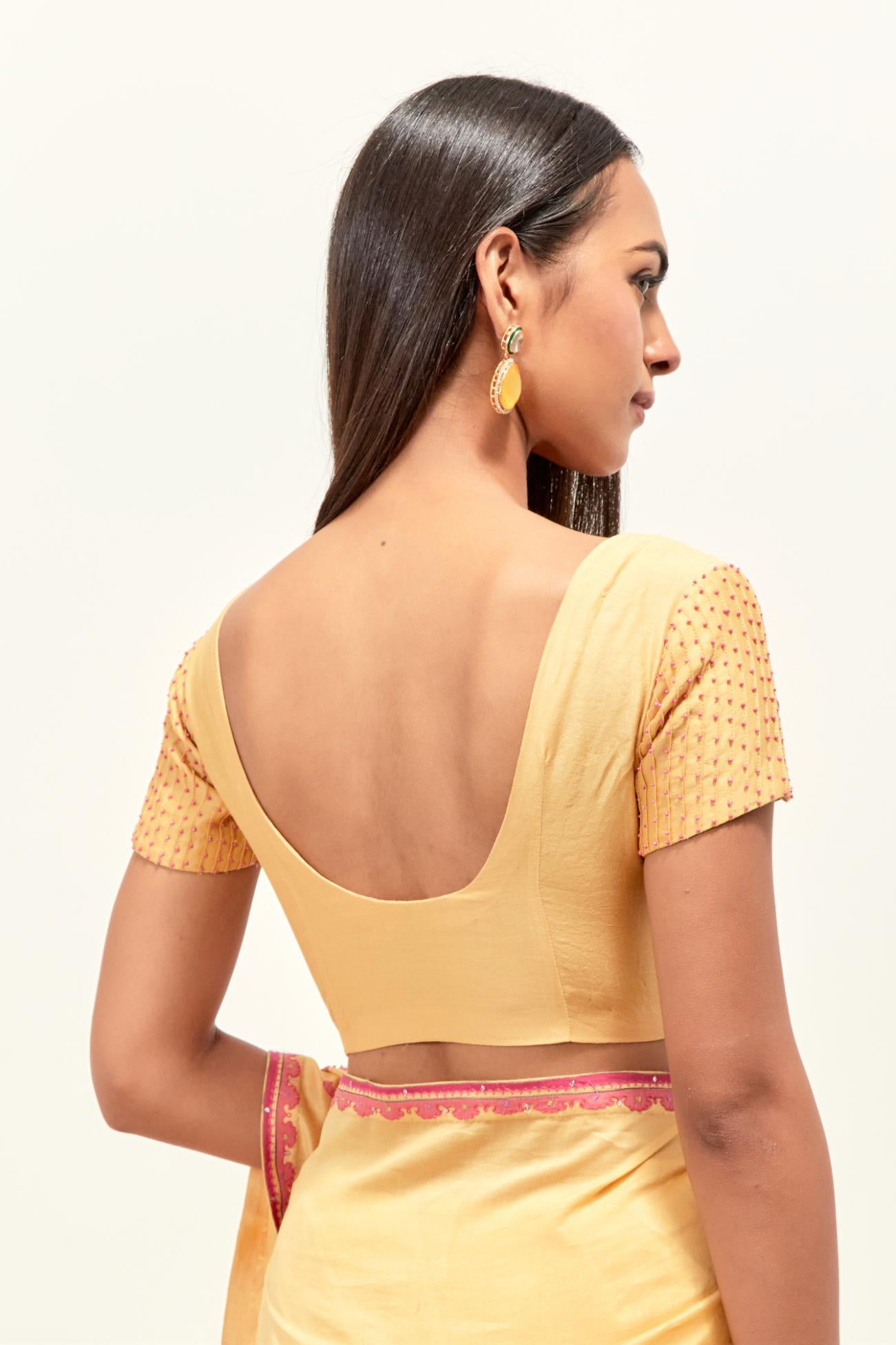 Yellow silk chanderi saree with all-over applique floral boota, highlighted with aari thread work and sequins, paired with yellow silk chanderi blouse with pin tucks in front, highlighted with bead work.