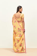 Yellow silk chanderi saree with all-over applique floral boota, highlighted with aari thread work and sequins, paired with yellow silk chanderi blouse with pin tucks in front, highlighted with bead work.