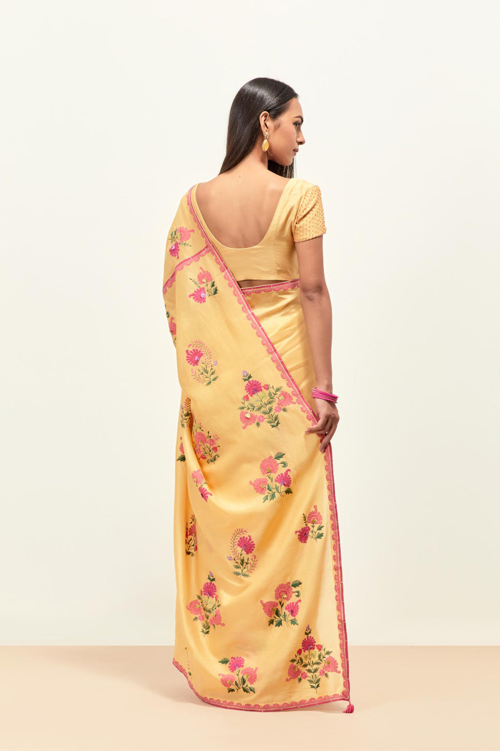Yellow silk chanderi saree with all-over applique floral boota, highlighted with aari thread work and sequins, paired with yellow silk chanderi blouse with pin tucks in front, highlighted with bead work.