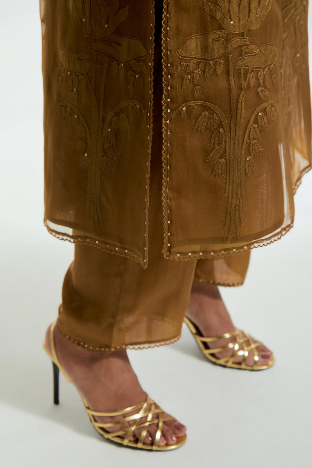An olive straight silk organza kurta set featuring a round neckline, adorned with delicately placed silk floral boota appliqués and sequin work.