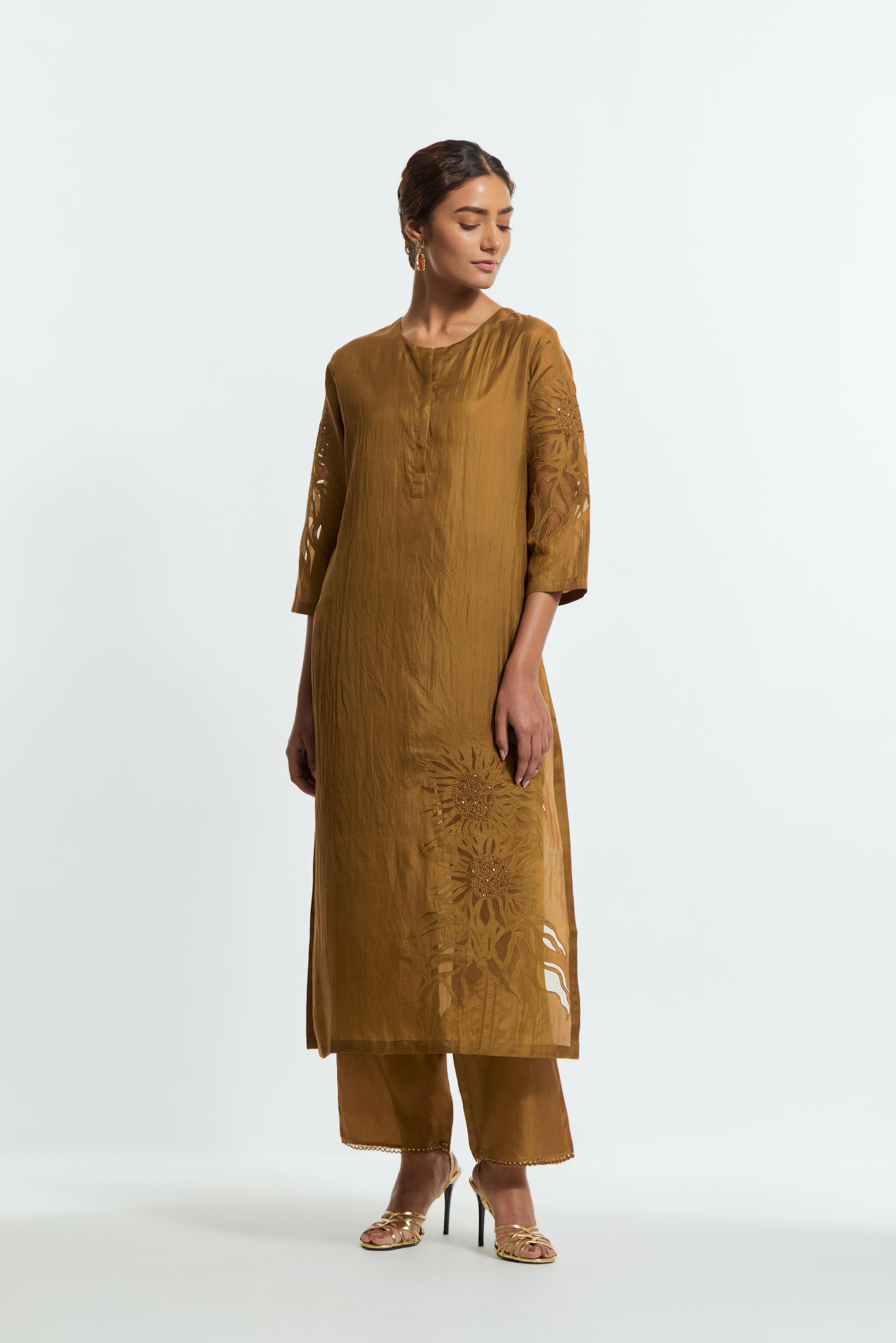 Olive silk straight kurta set adorned with appliqué chrysanthemum motifs along one side and both sleeves, delicately highlighted with fine French knots and subtle sequins.