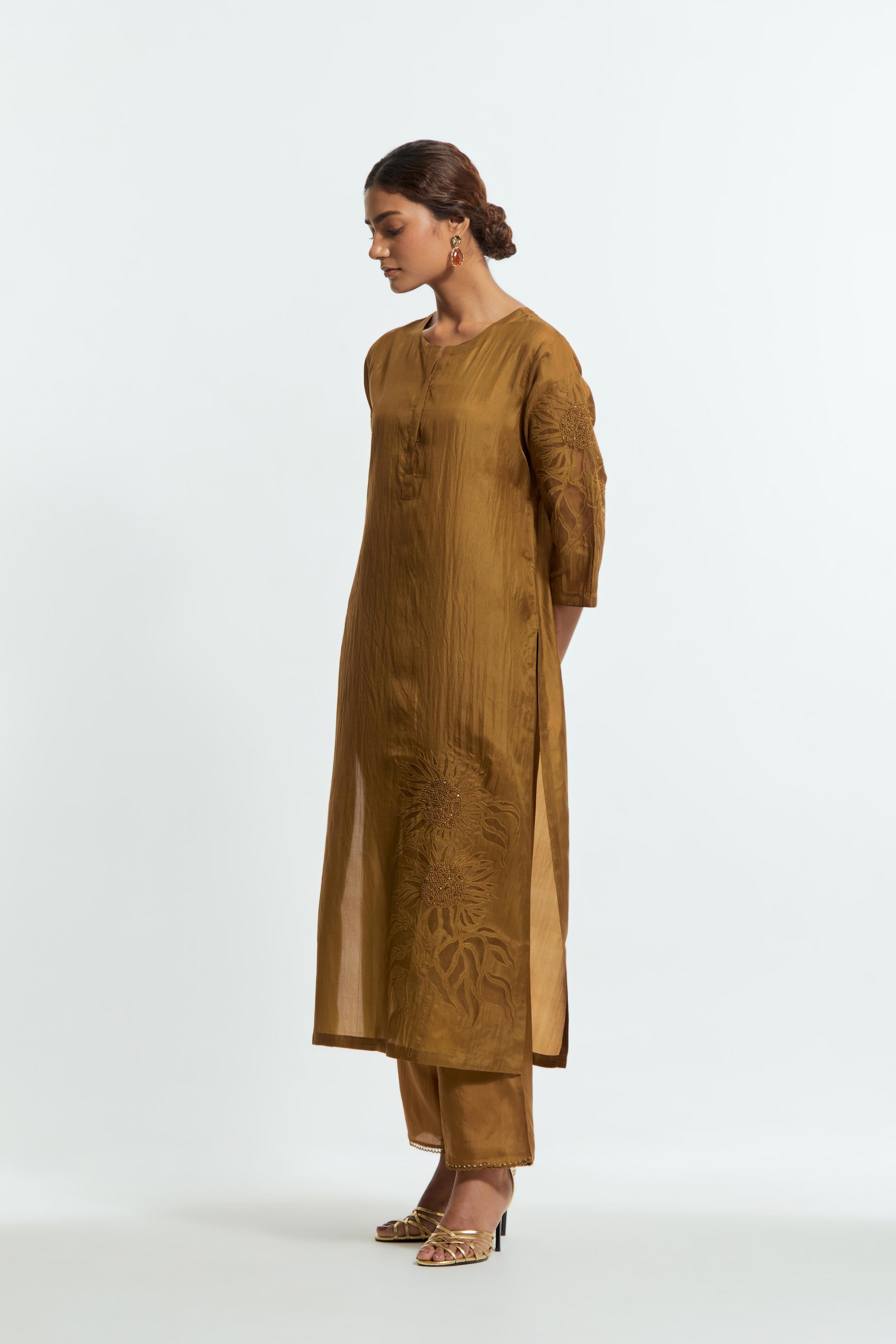Olive silk straight kurta set adorned with appliqué chrysanthemum motifs along one side and both sleeves, delicately highlighted with fine French knots and subtle sequins.