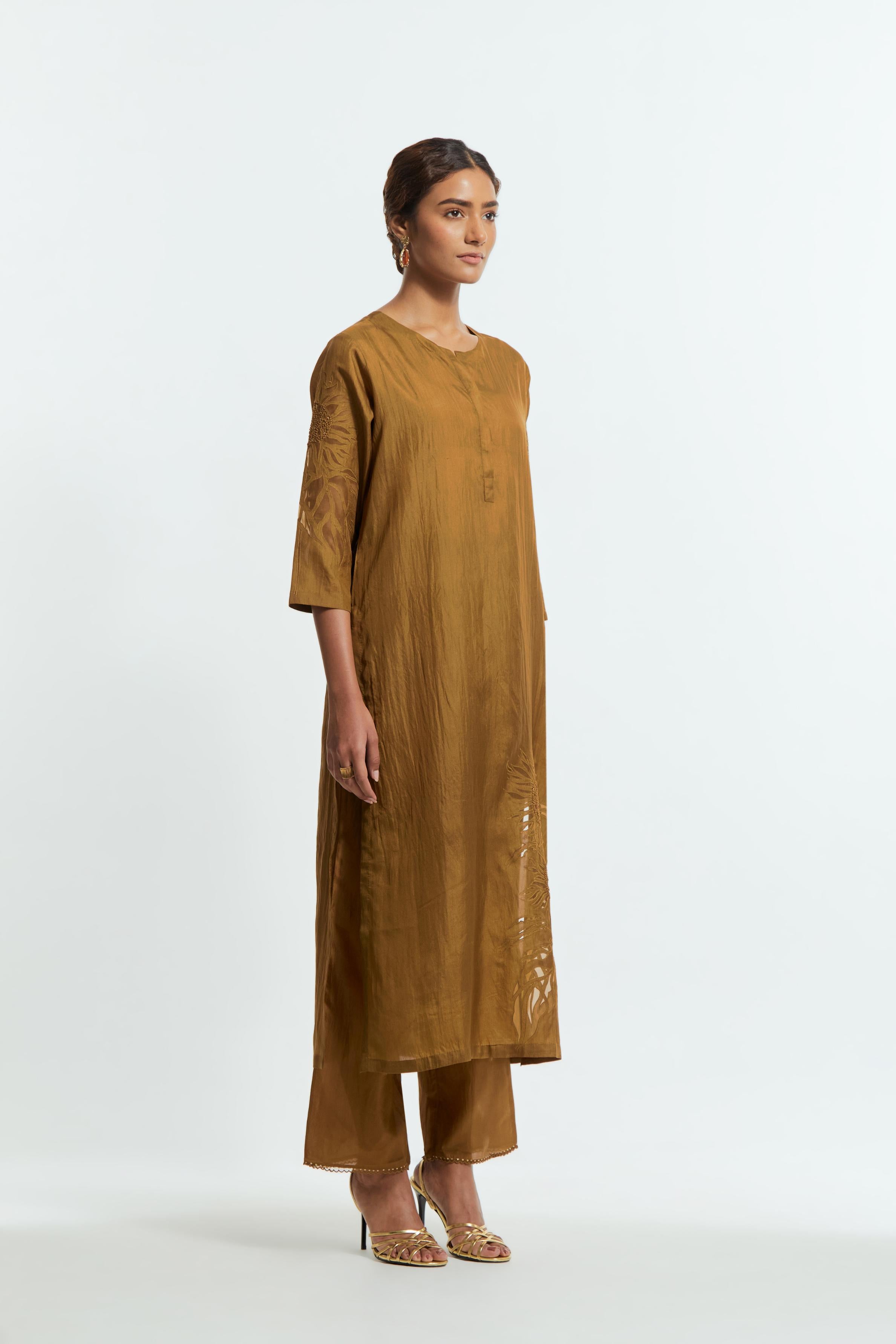 Olive silk straight kurta set adorned with appliqué chrysanthemum motifs along one side and both sleeves, delicately highlighted with fine French knots and subtle sequins.