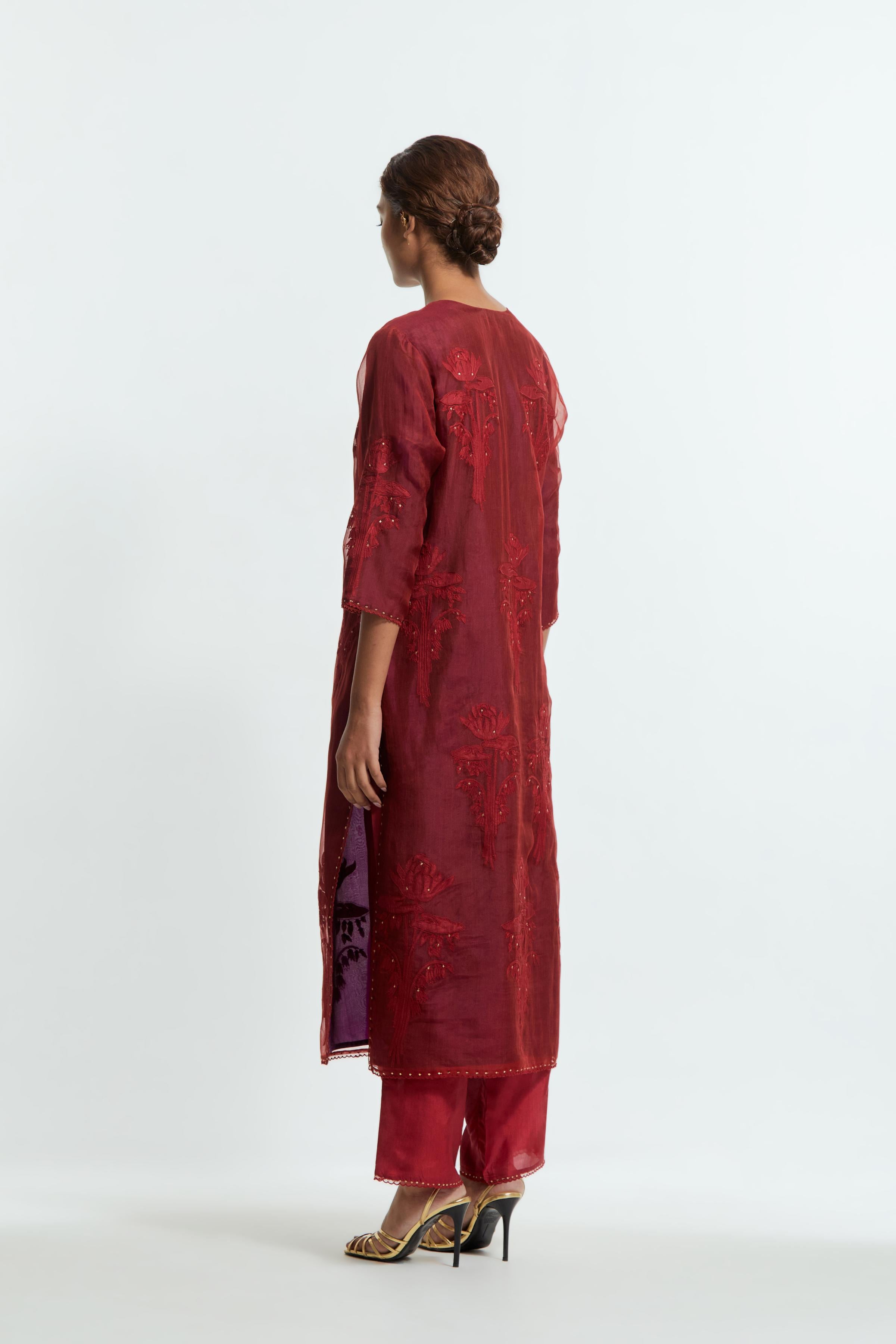 A Red straight silk organza kurta set featuring a round neckline, adorned with delicately placed silk floral boota appliqués and sequin work.