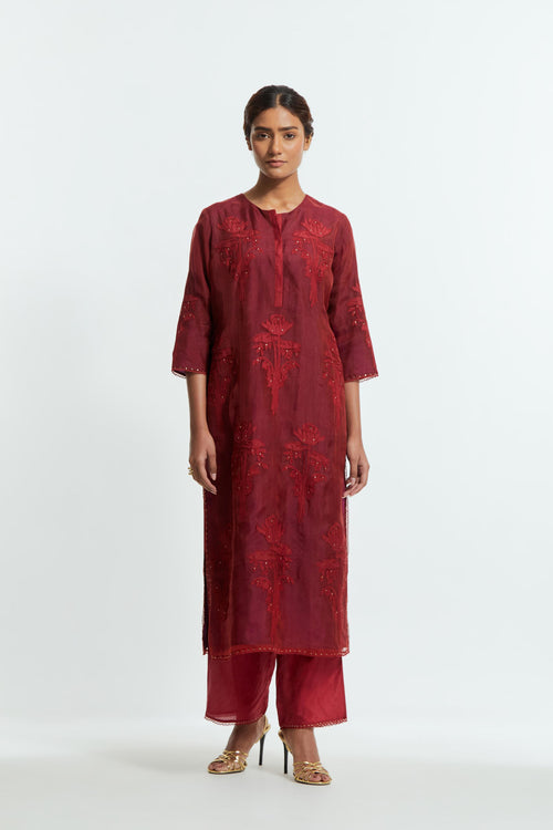 A Red straight silk organza kurta set featuring a round neckline, adorned with delicately placed silk floral boota appliqués and sequin work.