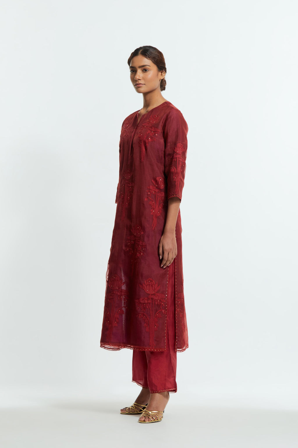 A Red straight silk organza kurta set featuring a round neckline, adorned with delicately placed silk floral boota appliqués and sequin work.