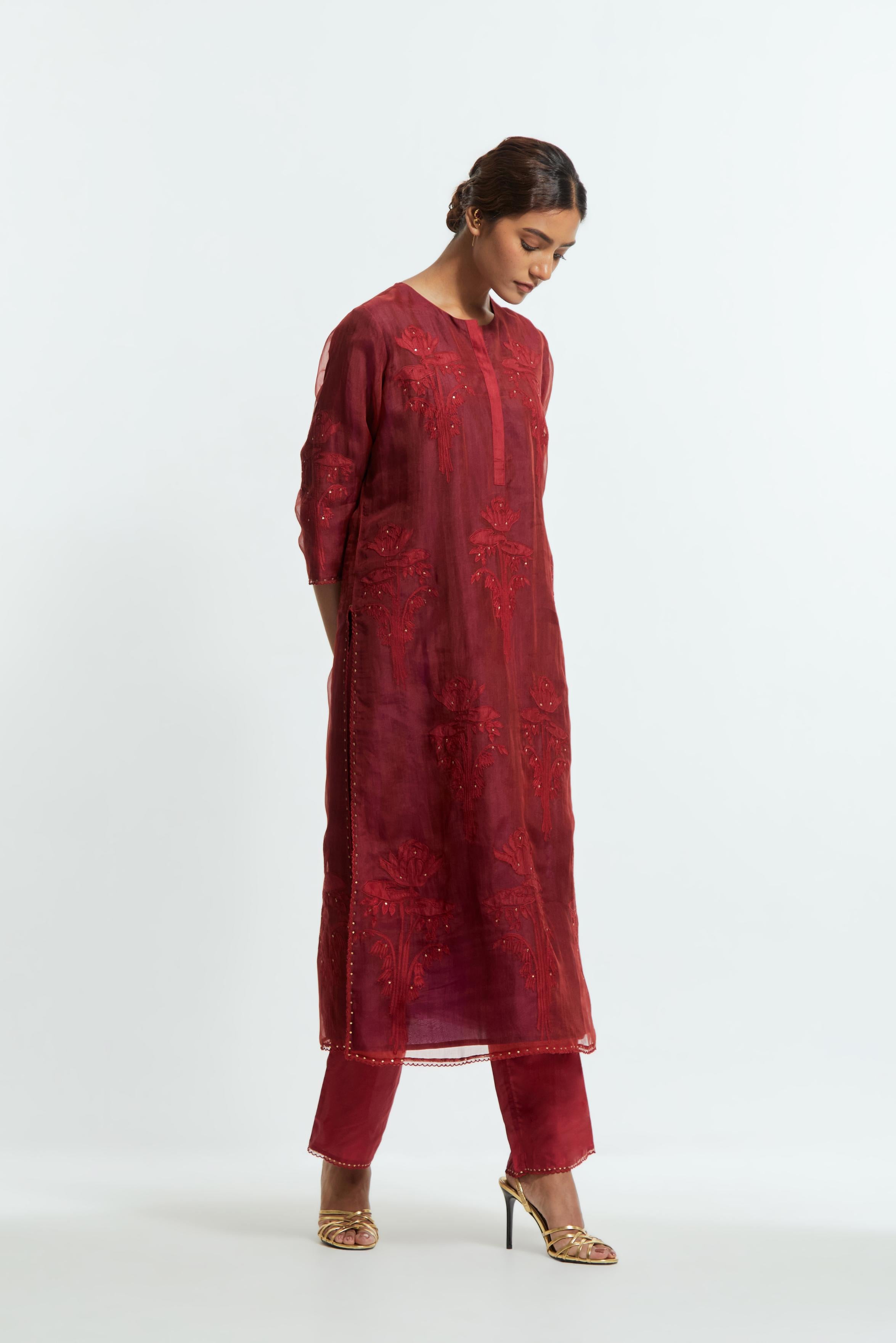 A Red straight silk organza kurta set featuring a round neckline, adorned with delicately placed silk floral boota appliqués and sequin work.