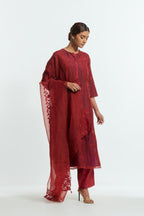 A Red straight silk organza kurta set featuring a round neckline, adorned with delicately placed silk floral boota appliqués and sequin work.