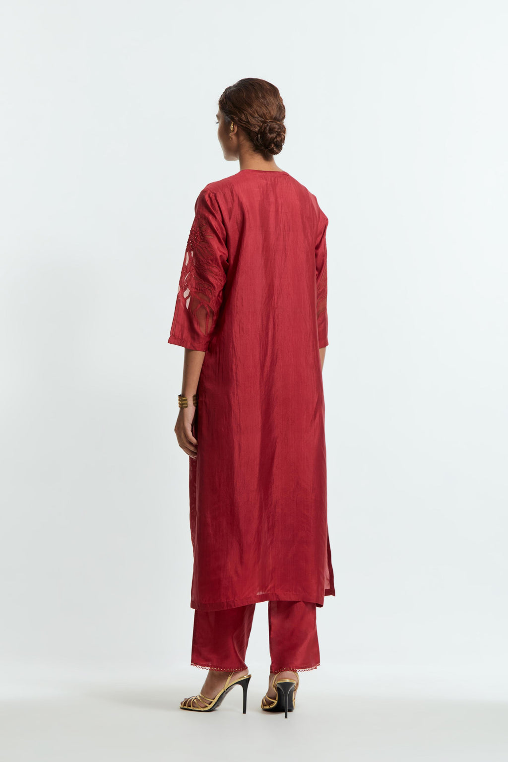 Red silk straight kurta set adorned with appliqué chrysanthemum motifs along one side and both sleeves, delicately highlighted with fine French knots and subtle sequins.