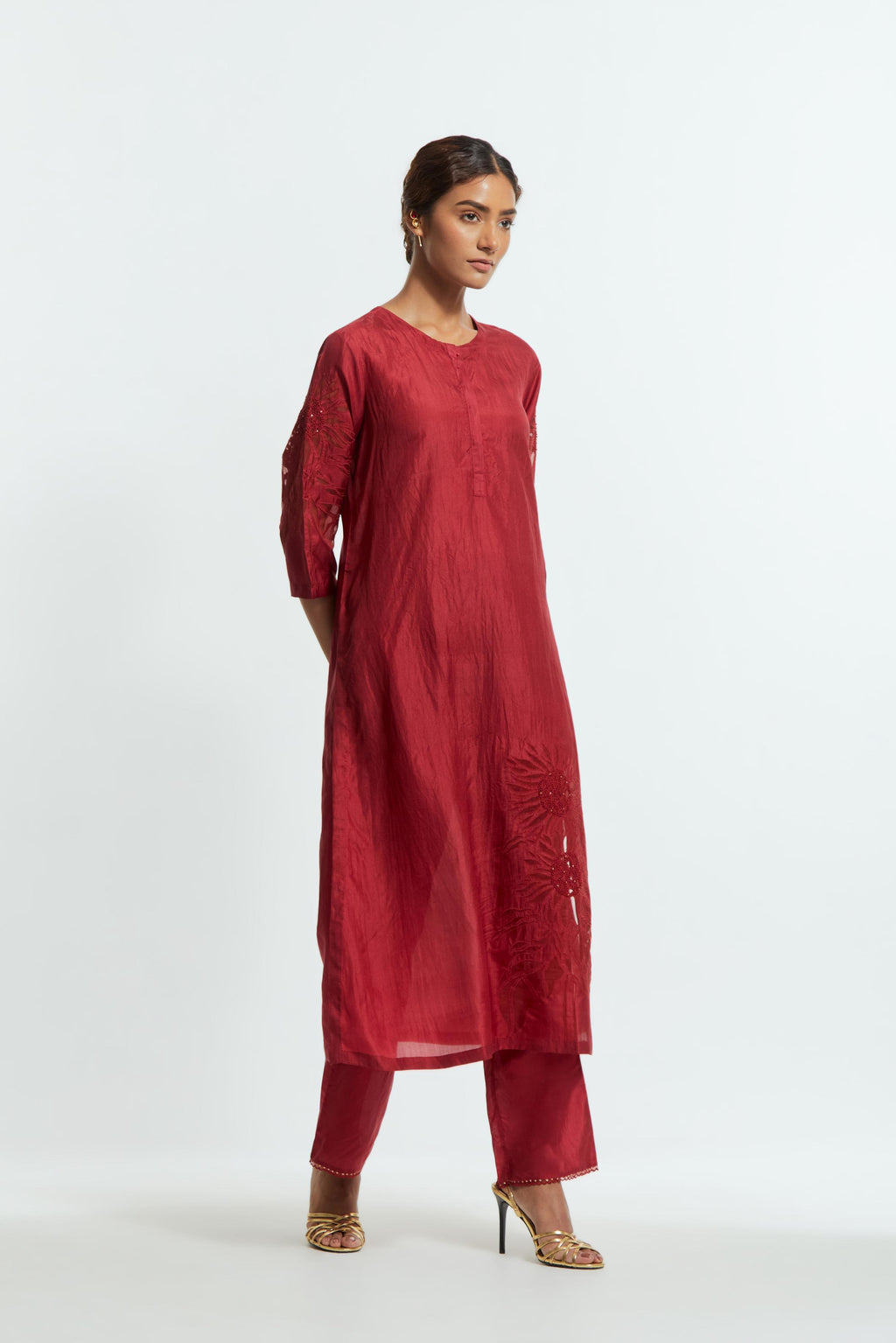 Red silk straight kurta set adorned with appliqué chrysanthemum motifs along one side and both sleeves, delicately highlighted with fine French knots and subtle sequins.