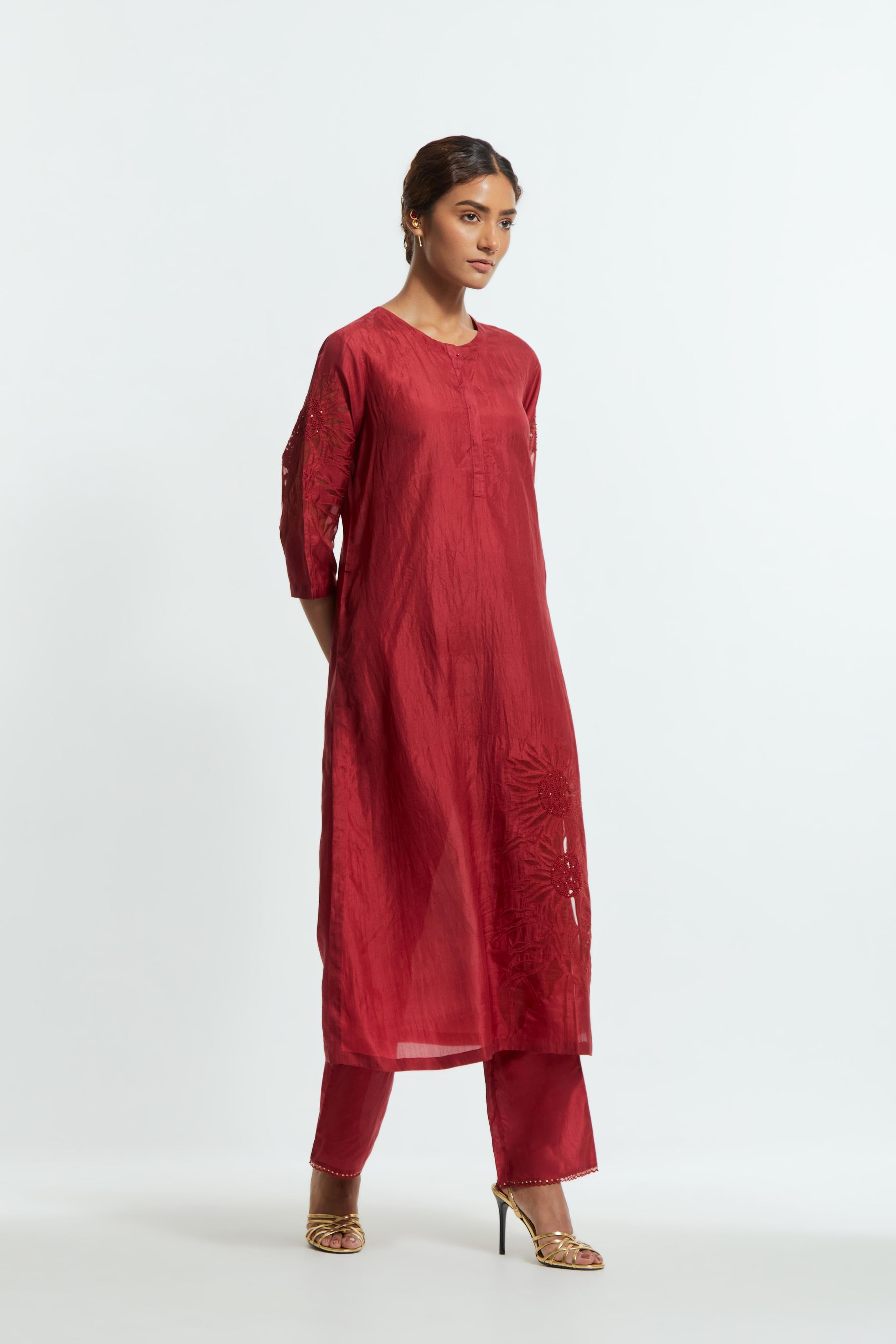 Red silk straight kurta set adorned with appliqué chrysanthemum motifs along one side and both sleeves, delicately highlighted with fine French knots and subtle sequins.