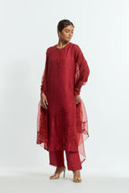 Red silk straight kurta set adorned with appliqué chrysanthemum motifs along one side and both sleeves, delicately highlighted with fine French knots and subtle sequins.