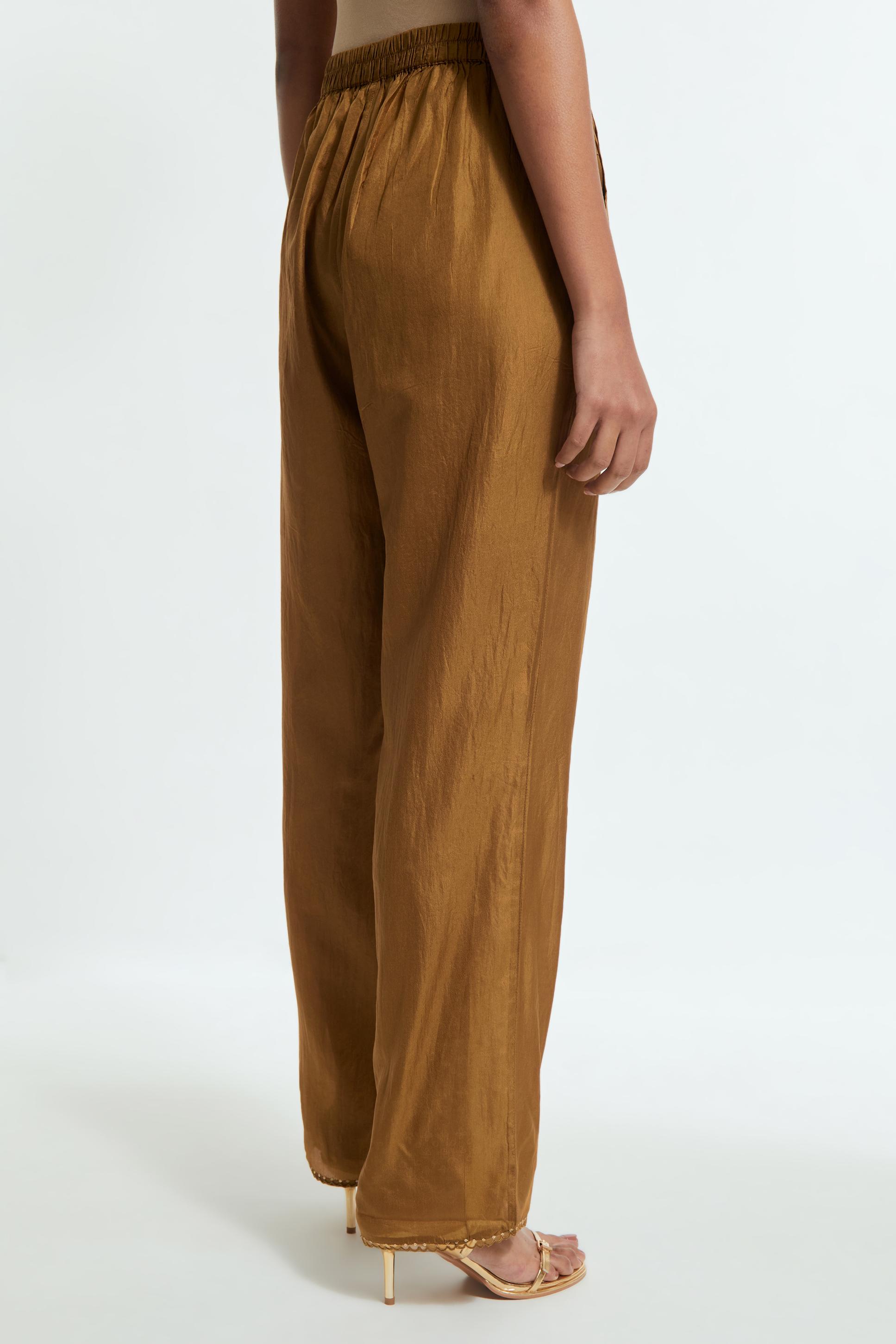 Olive silk straight pants detailed with scalloped organza edging at the hem, delicately highlighted with gold sequins work.
