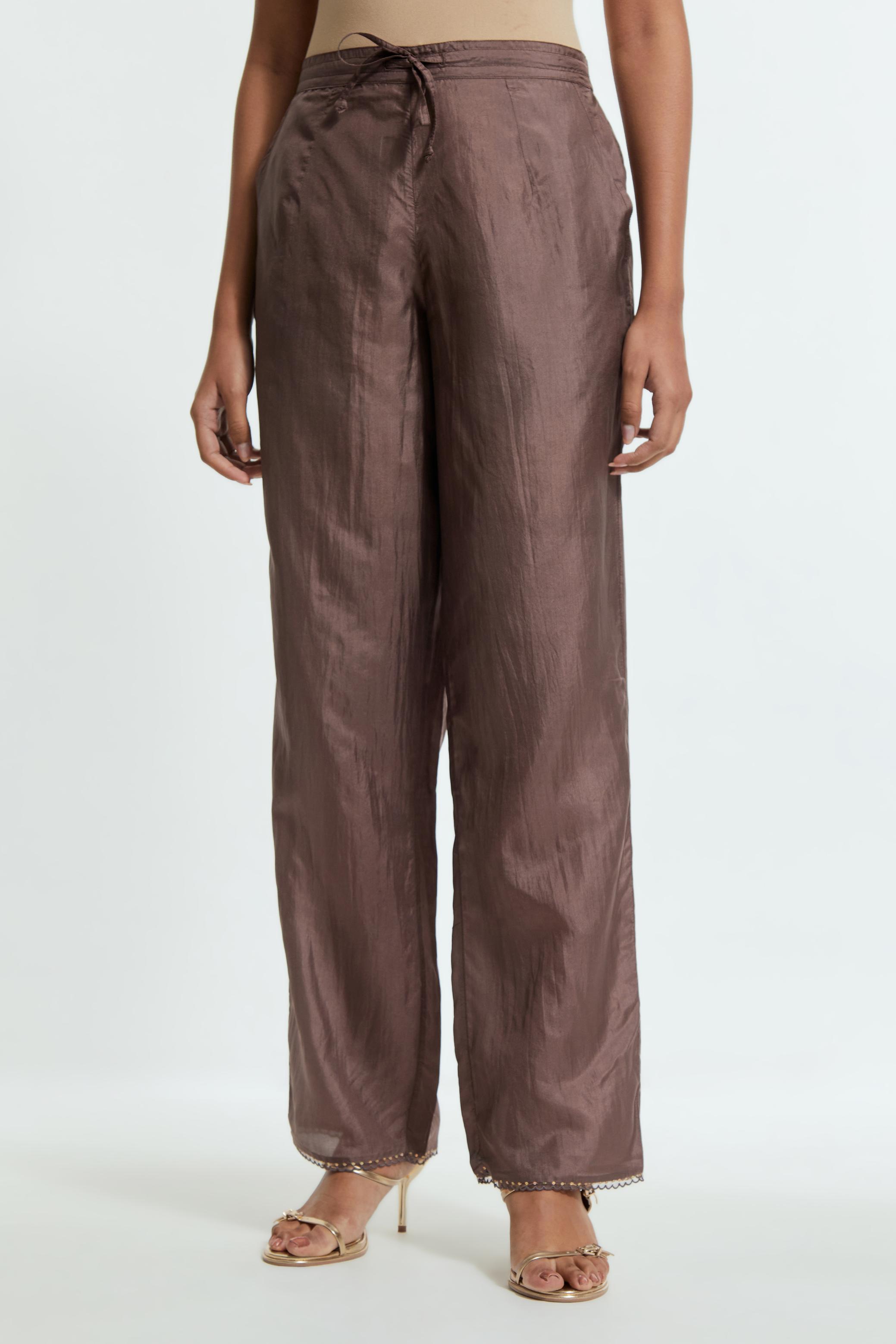 Grey silk straight pants detailed with scalloped organza edging at the hem, delicately highlighted with gold sequins work.