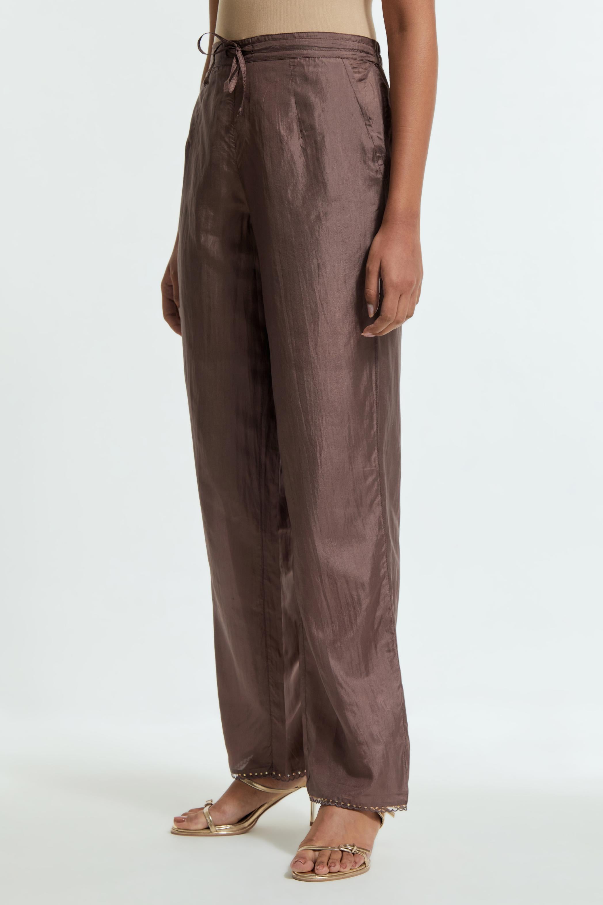 Grey silk straight pants detailed with scalloped organza edging at the hem, delicately highlighted with gold sequins work.