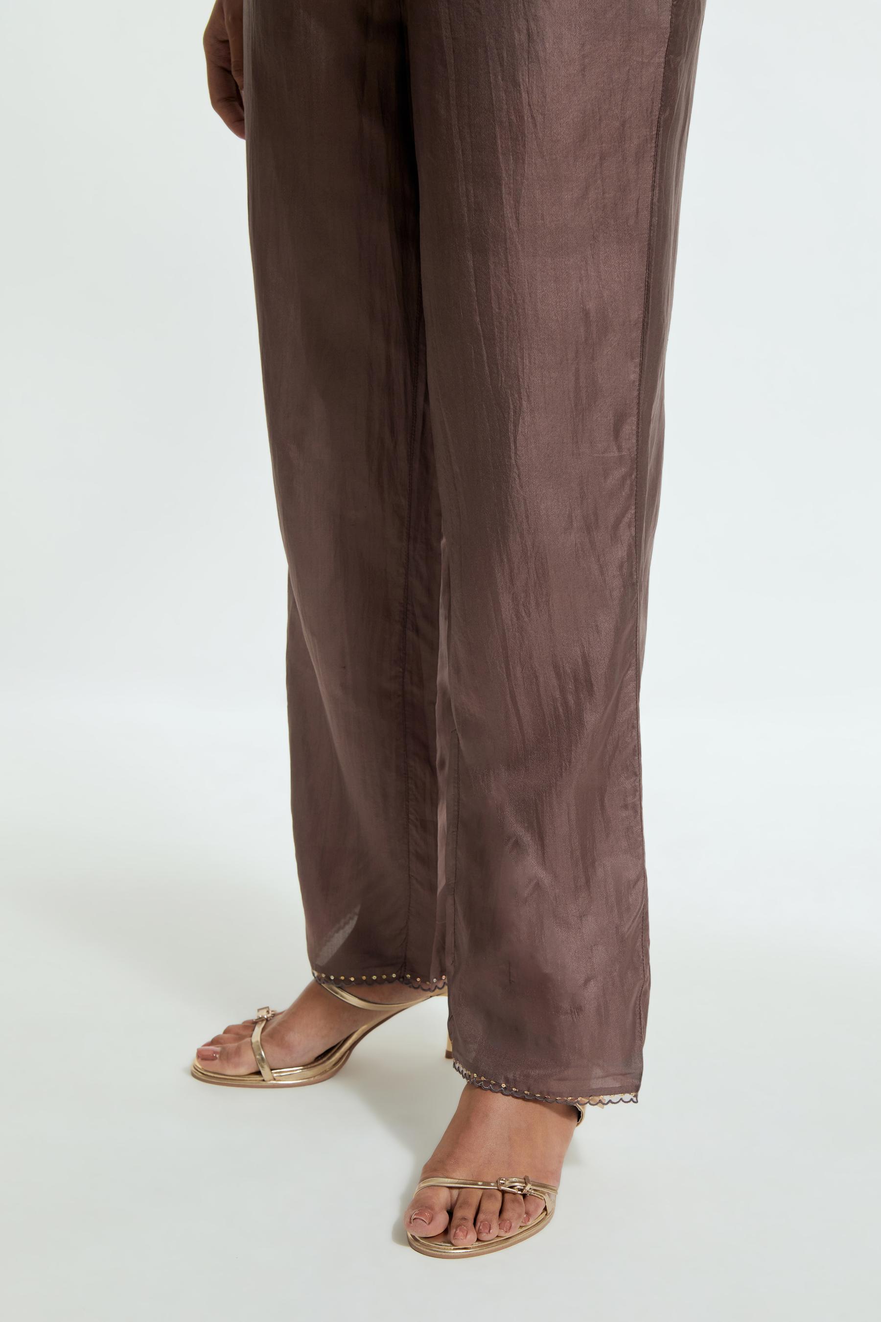 Grey silk straight pants detailed with scalloped organza edging at the hem, delicately highlighted with gold sequins work.