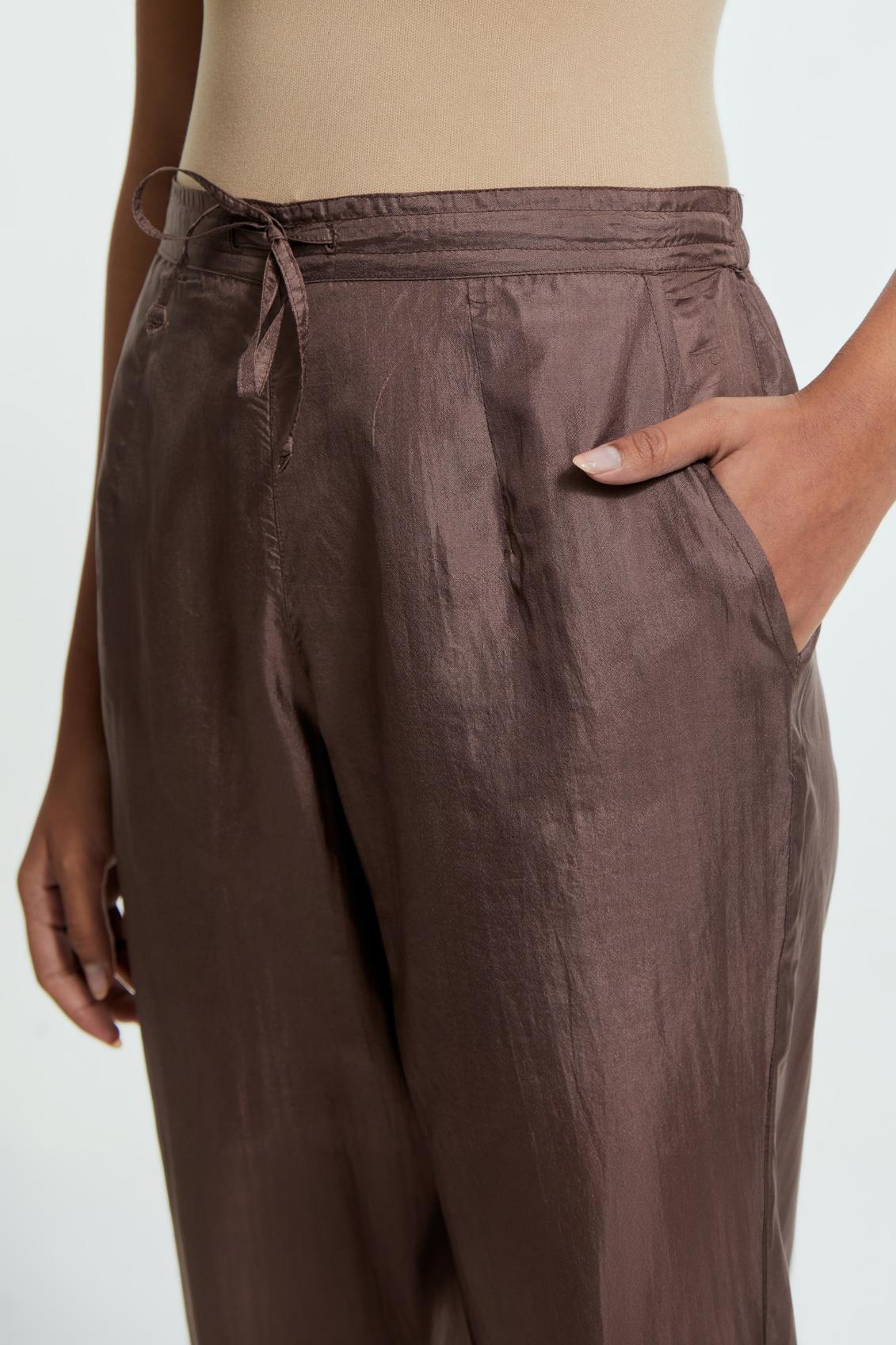 Grey silk straight pants detailed with scalloped organza edging at the hem, delicately highlighted with gold sequins work.