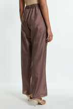 Grey silk straight pants detailed with scalloped organza edging at the hem, delicately highlighted with gold sequins work.