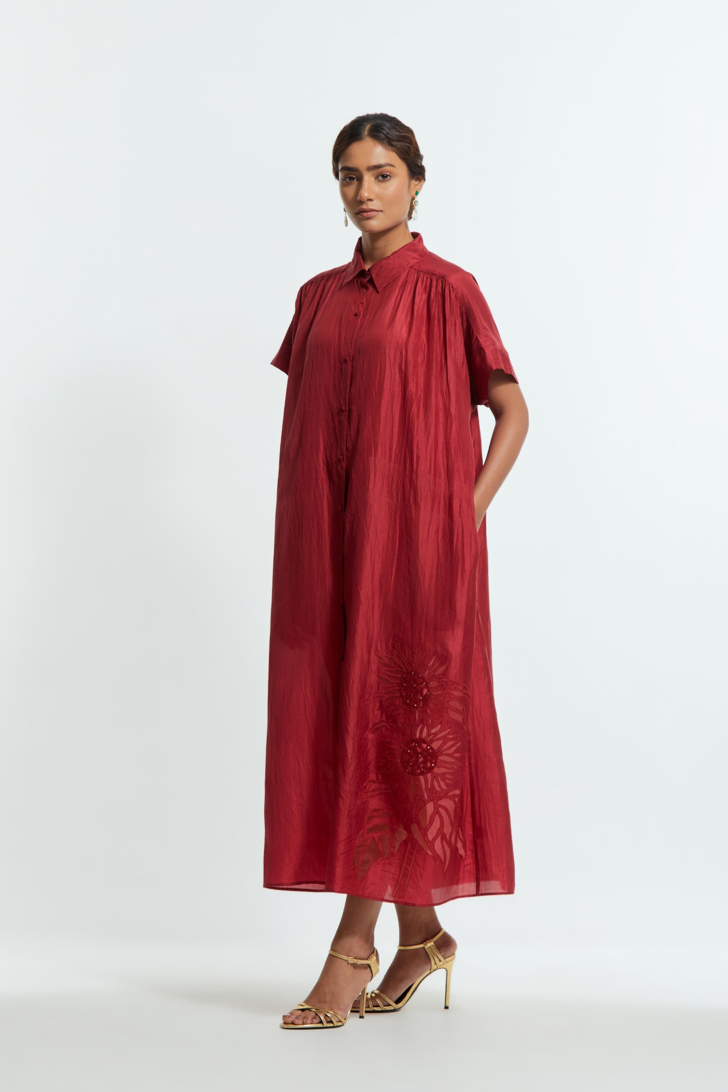 Red silk long dress adorned with appliqué chrysanthemum floral motifs along one side, delicately highlighted with fine French knots and subtle sequins.
