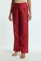 Red silk straight pants detailed with scalloped organza edging at the hem, delicately highlighted with gold sequins work.