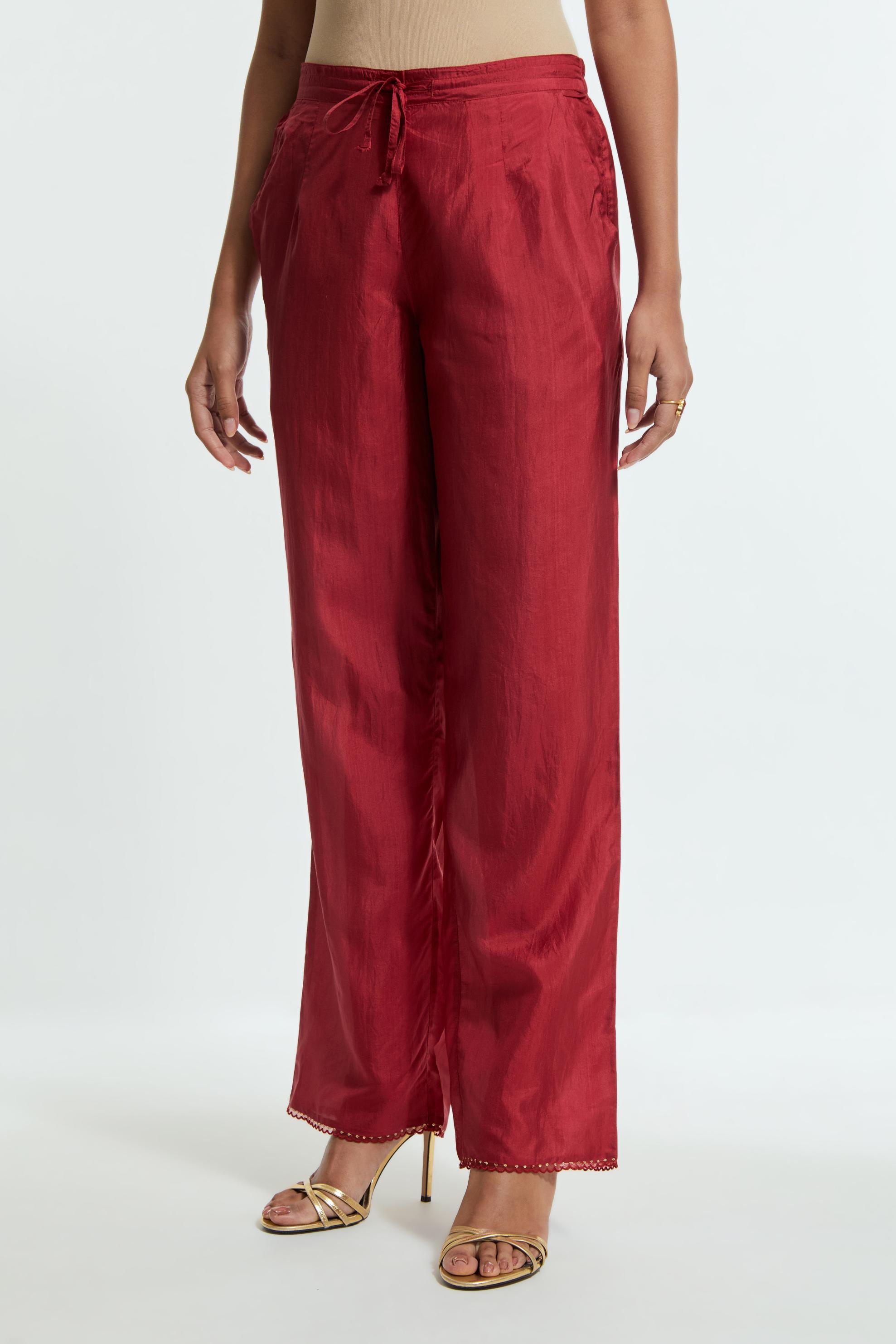Red silk straight pants detailed with scalloped organza edging at the hem, delicately highlighted with gold sequins work.