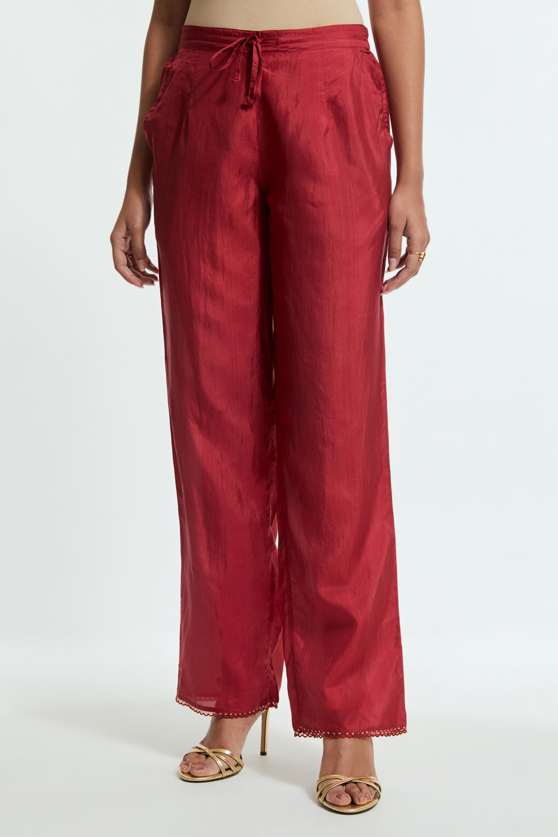 Red silk straight pants detailed with scalloped organza edging at the hem, delicately highlighted with gold sequins work.