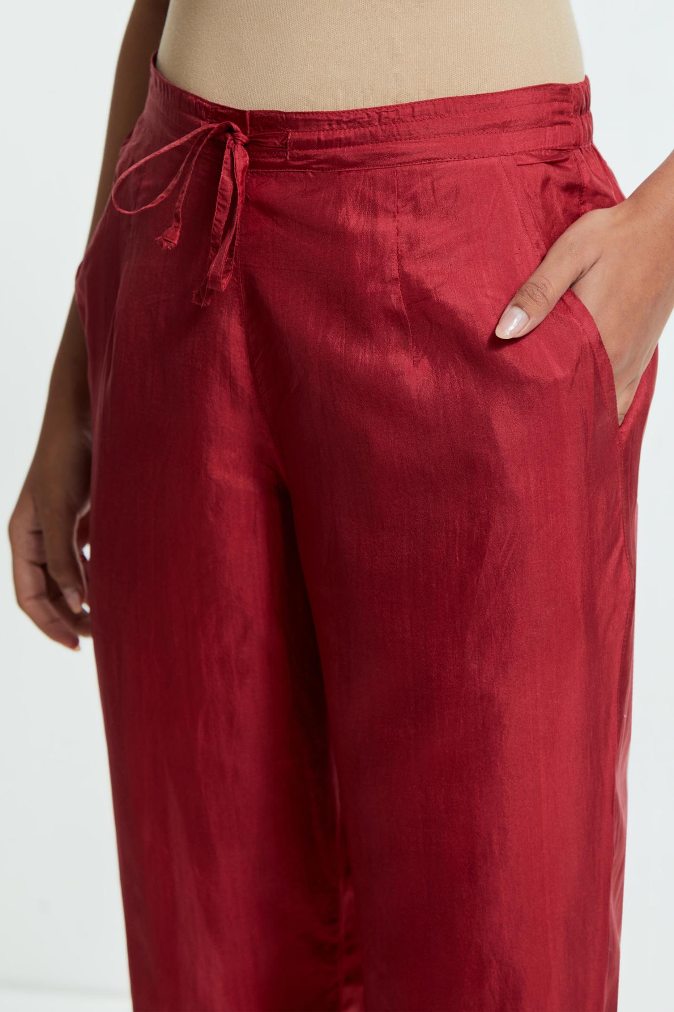 Red silk straight pants detailed with scalloped organza edging at the hem, delicately highlighted with gold sequins work.