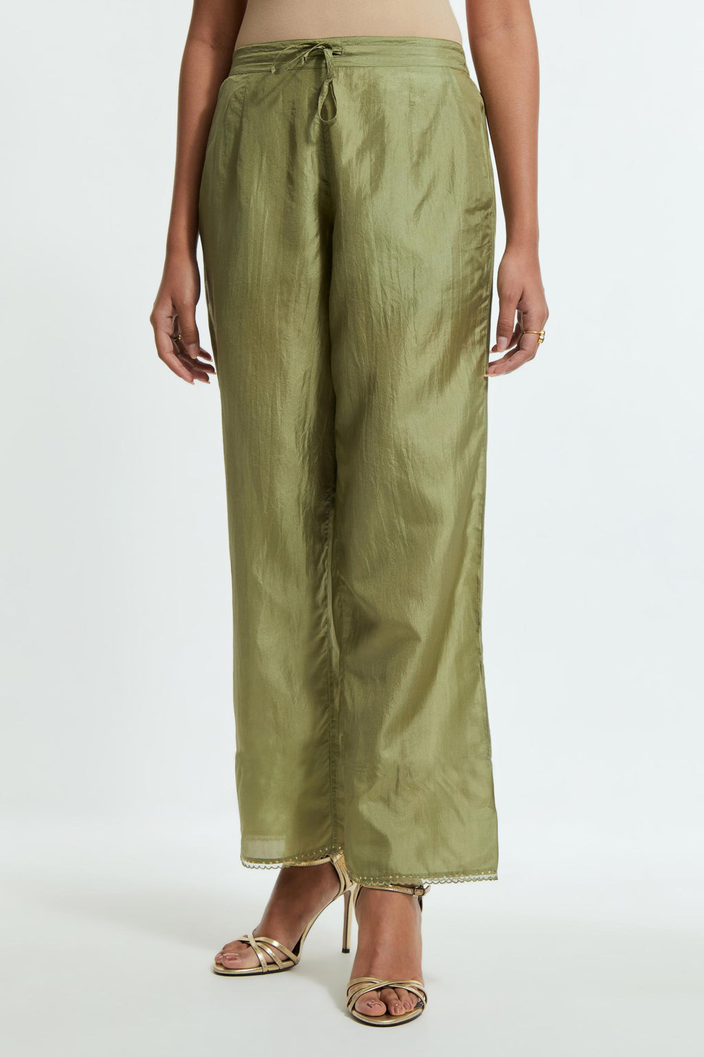 Green silk straight pants detailed with scalloped organza edging at the hem, delicately highlighted with gold sequins work.