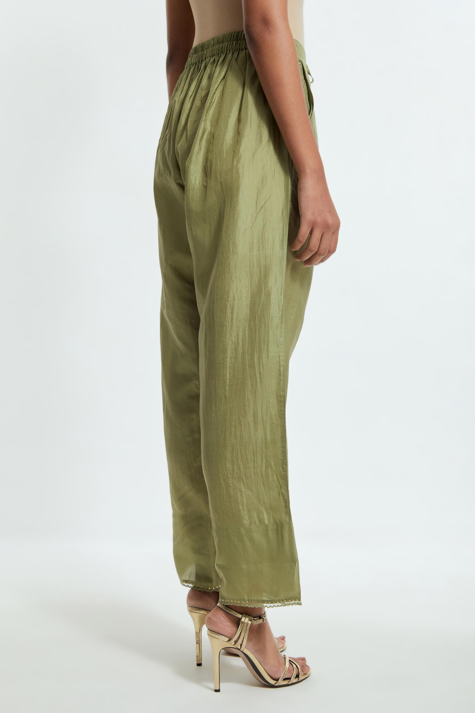 Green silk straight pants detailed with scalloped organza edging at the hem, delicately highlighted with gold sequins work.