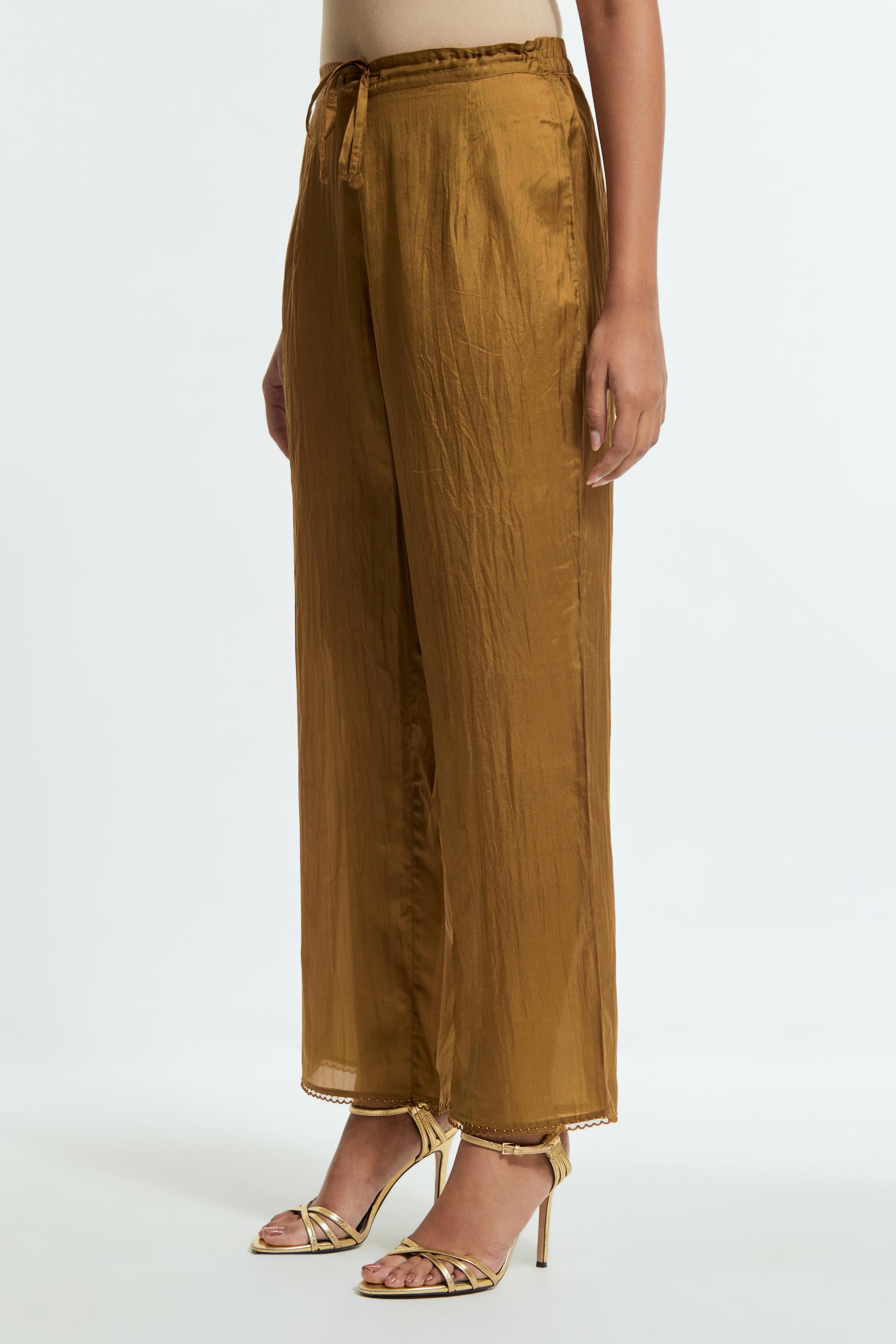 Olive silk straight pants detailed with scalloped organza edging at the hem, delicately highlighted with tonal beadwork.