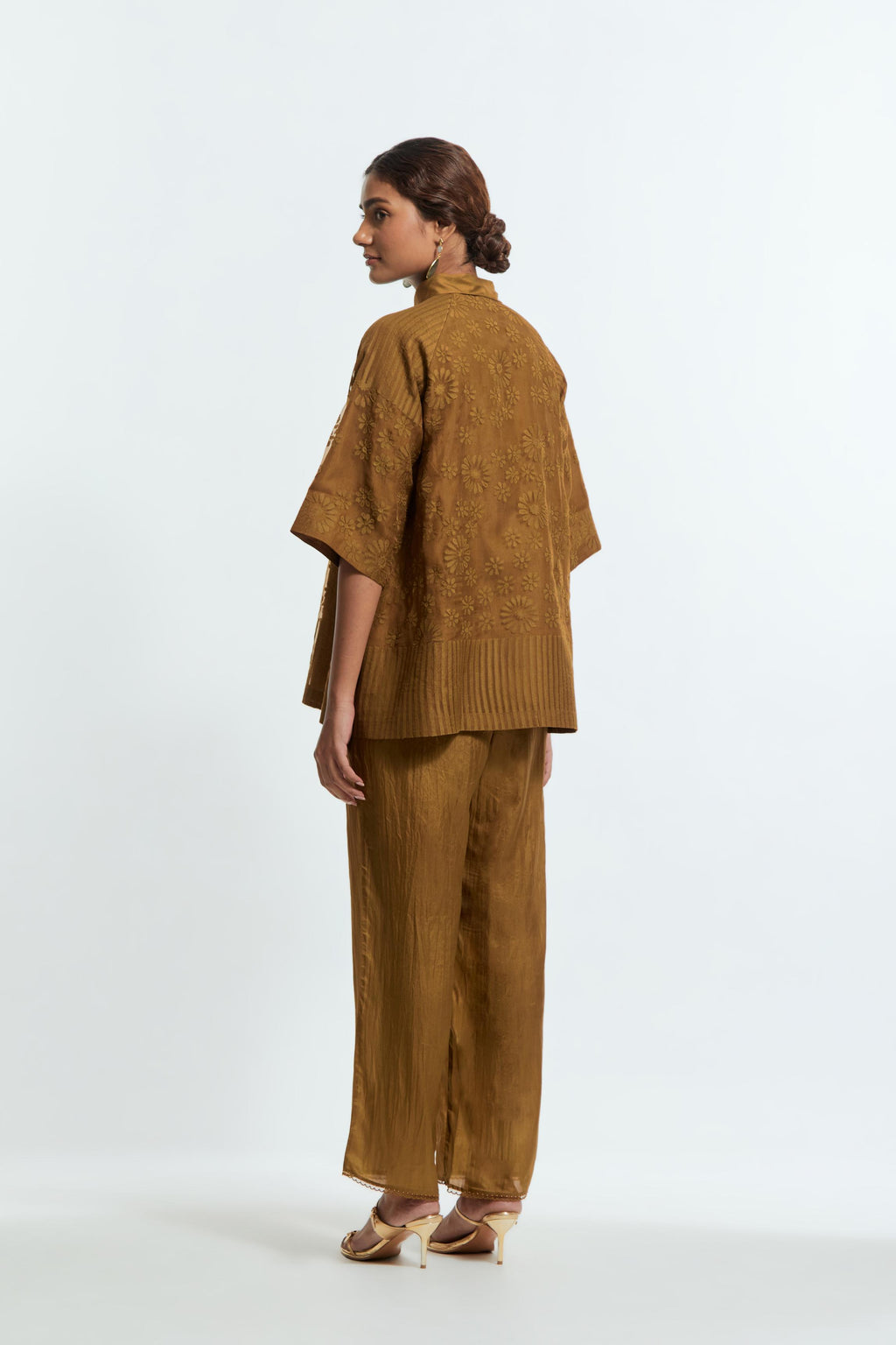 Olive silk organza short top featuring silk appliqué floral motifs and a shirt collar neckline. Paired with Olive silk straight pants detailed with scalloped organza edging at the hem, delicately highlighted with tonal beadwork.