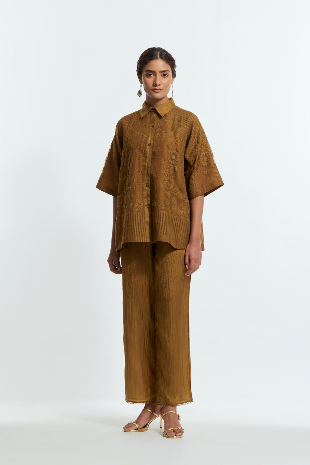 Olive silk organza short top featuring silk appliqué floral motifs and a shirt collar neckline. Paired with Olive silk straight pants detailed with scalloped organza edging at the hem, delicately highlighted with tonal beadwork.