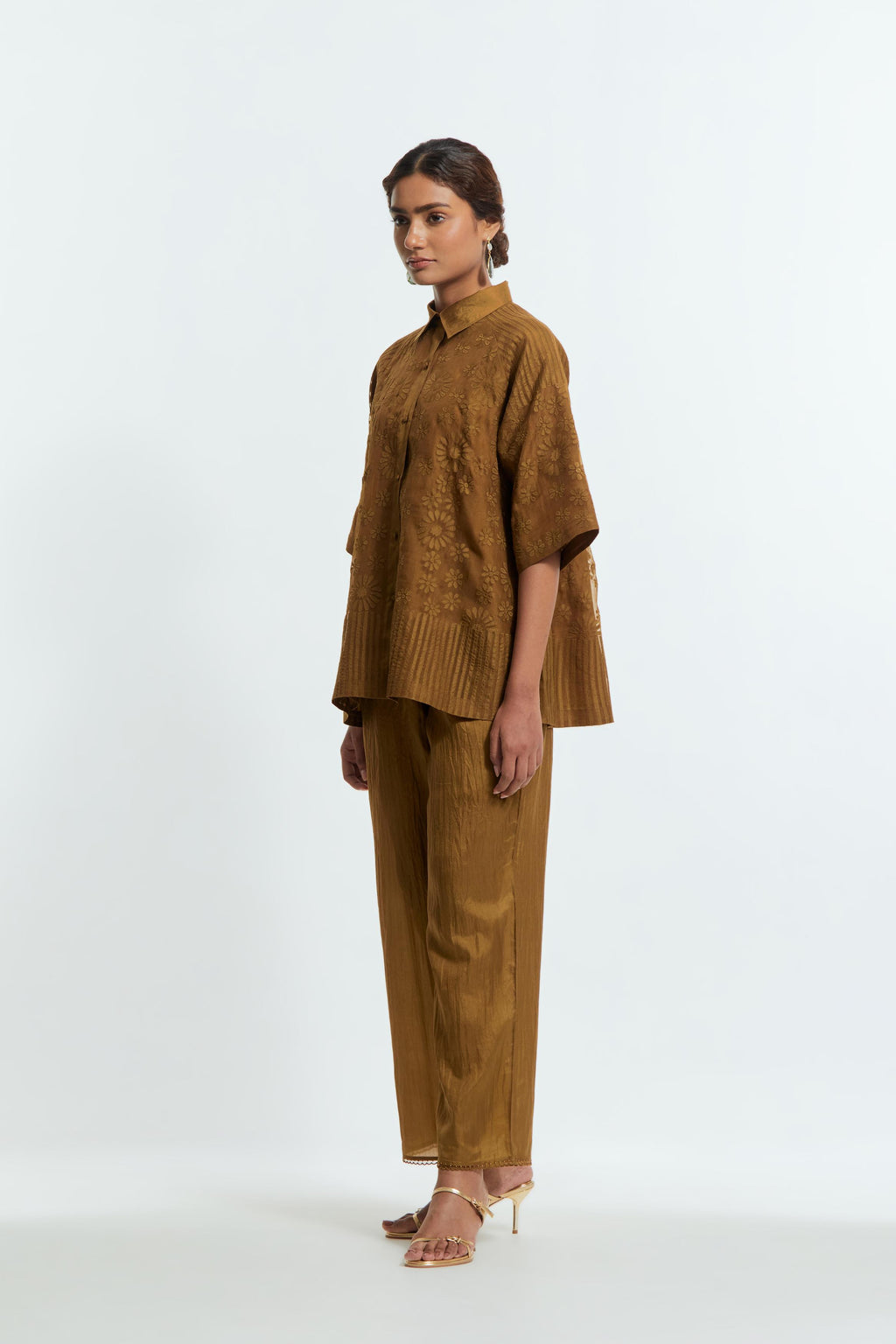 Olive silk organza short top featuring silk appliqué floral motifs and a shirt collar neckline. Paired with Olive silk straight pants detailed with scalloped organza edging at the hem, delicately highlighted with tonal beadwork.