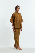 Olive silk organza short top featuring silk appliqué floral motifs and a shirt collar neckline. Paired with Olive silk straight pants detailed with scalloped organza edging at the hem, delicately highlighted with tonal beadwork.