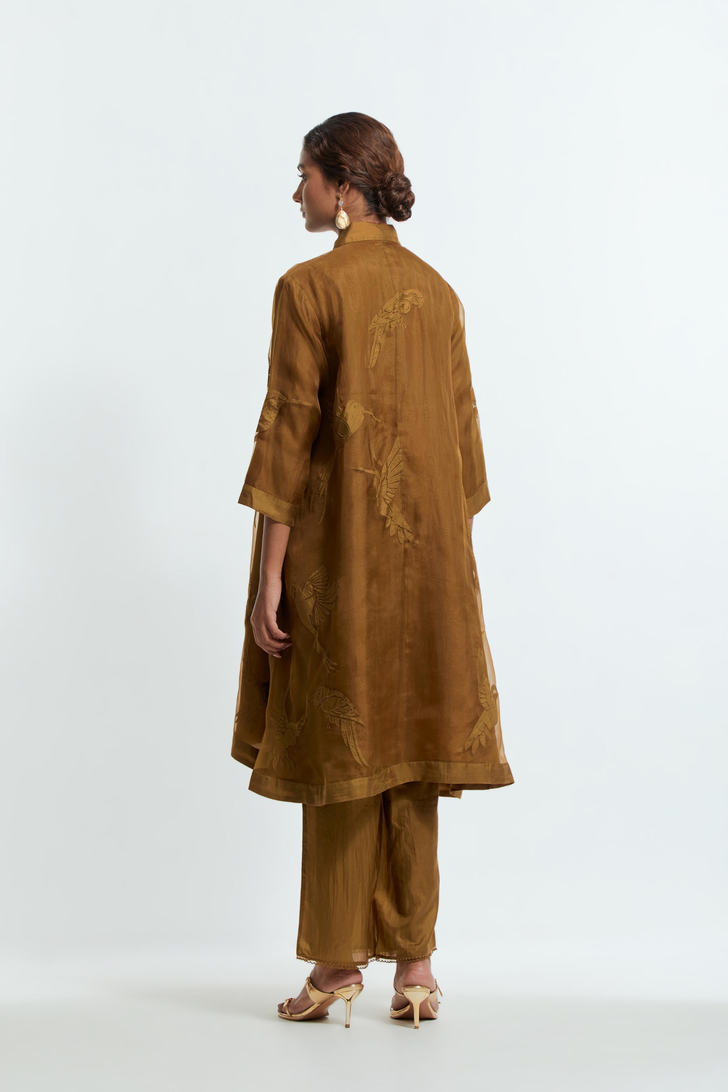 Olive silk organza A-line short kurta featuring appliqué bird motifs gracefully placed across the front, back and sleeves. Paired with Olive silk straight pants detailed with scalloped organza edging at the hem, delicately highlighted with tonal beadwork.