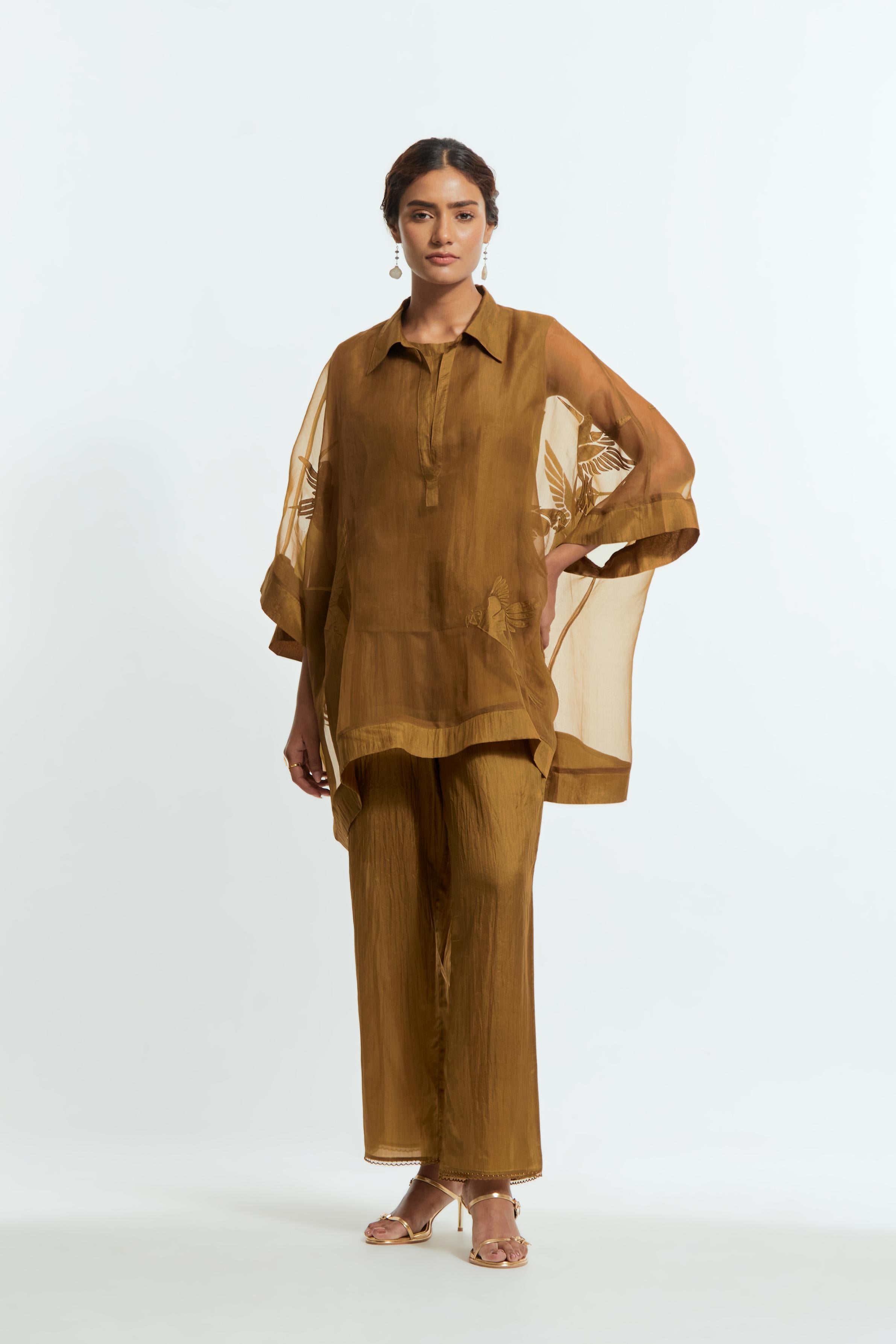 Olive silk organza short kaftan top with a sheer finish, delicately adorned with appliqué bird motifs along the hem and sides. Paired with olive silk straight pants detailed with scalloped organza edging at hem, delicately highlighted with tonal beadwork.