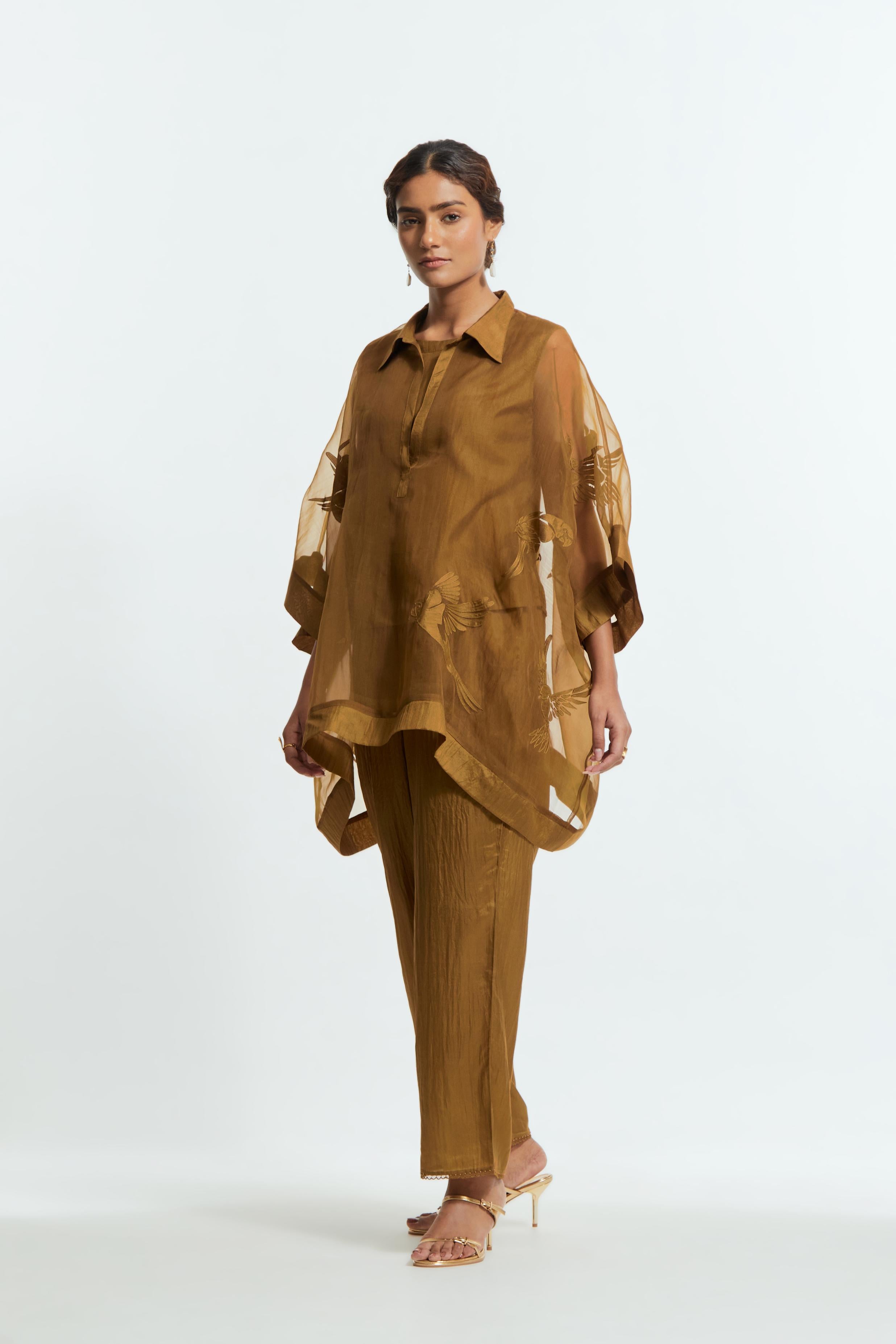 Olive silk organza short kaftan top with a sheer finish, delicately adorned with appliqué bird motifs along the hem and sides. Paired with olive silk straight pants detailed with scalloped organza edging at hem, delicately highlighted with tonal beadwork.