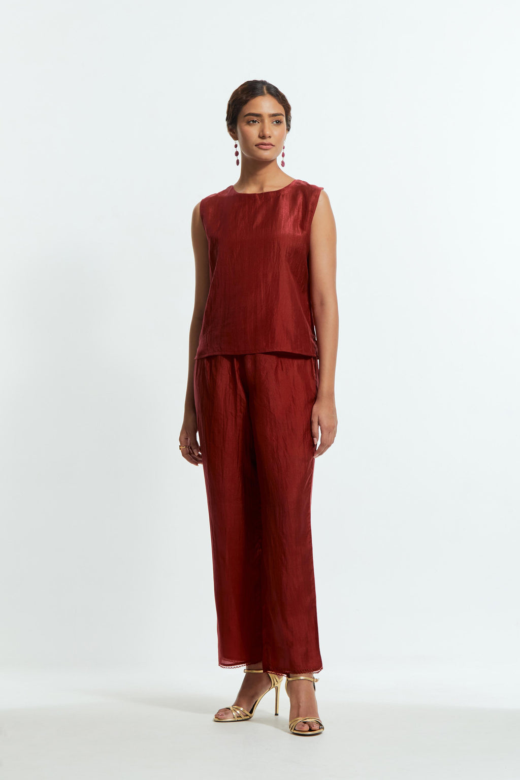 Red silk organza short kaftan top with a sheer finish, delicately adorned with appliqué bird motifs along the hem and sides. Paired with Red silk straight pants detailed with scalloped organza edging at the hem, delicately highlighted with tonal beadwork.