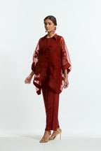 Red silk organza short kaftan top with a sheer finish, delicately adorned with appliqué bird motifs along the hem and sides. Paired with Red silk straight pants detailed with scalloped organza edging at the hem, delicately highlighted with tonal beadwork.